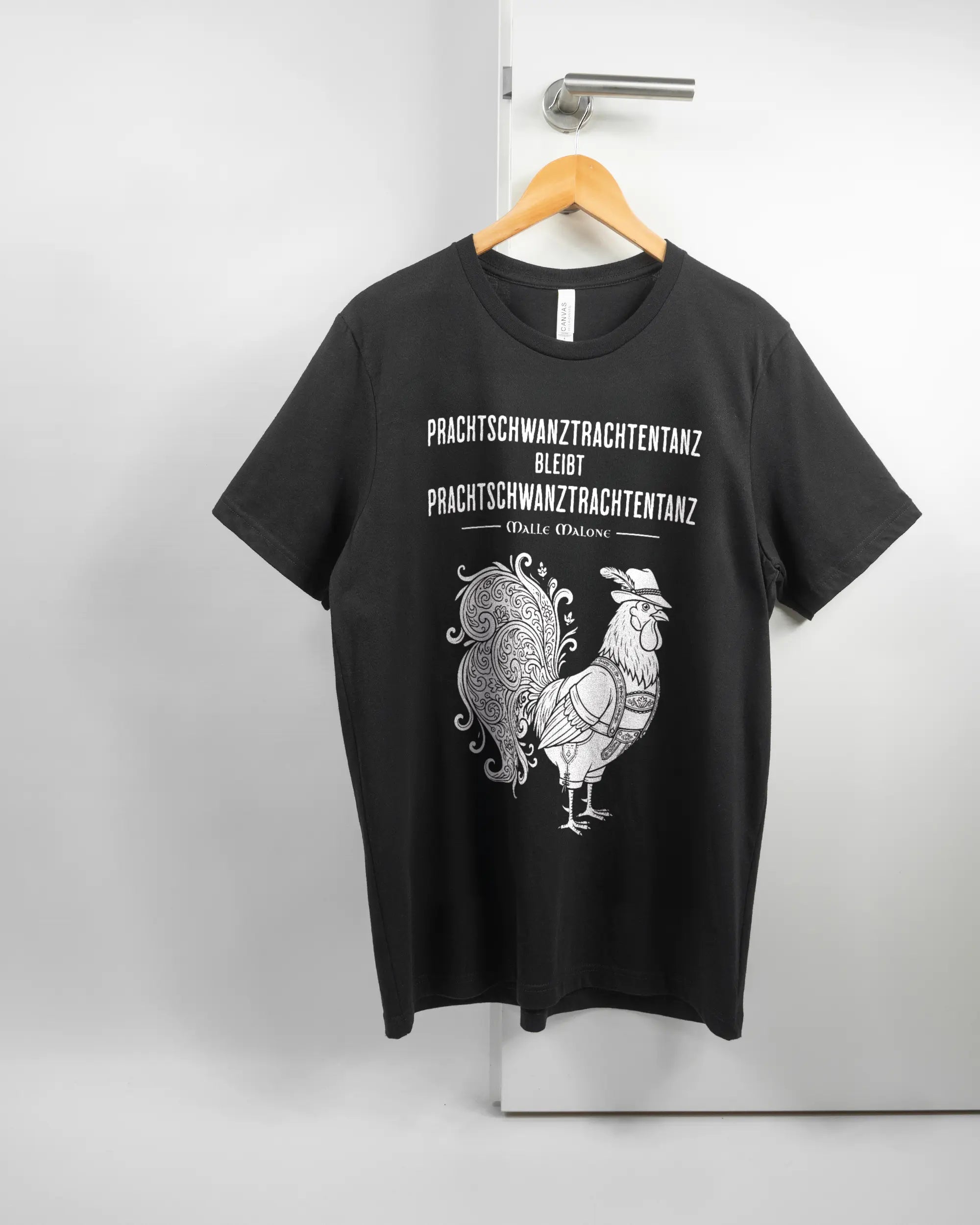 Vorderseite des Basic Unisex T-Shirt Light von Maondo mit dem Design Trachtentanz in der Farbe Black und in der Größe L auf einem Bügel an der Türklinke aufgehängt