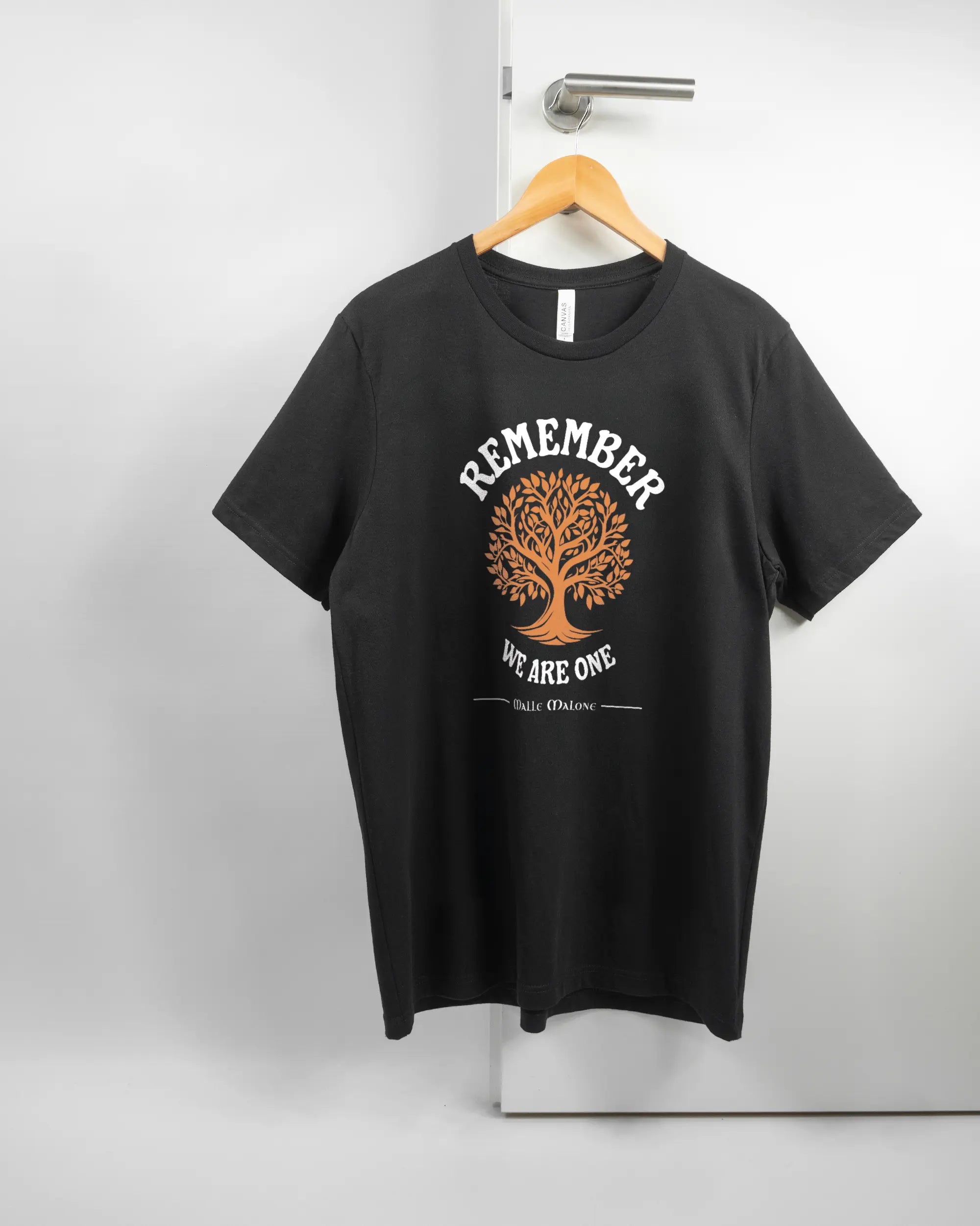 Vorderseite des Basic Unisex T-Shirt Light von Maondo mit dem Design We are one in der Farbe Black und in der Größe L auf einem Bügel an der Türklinke aufgehängt