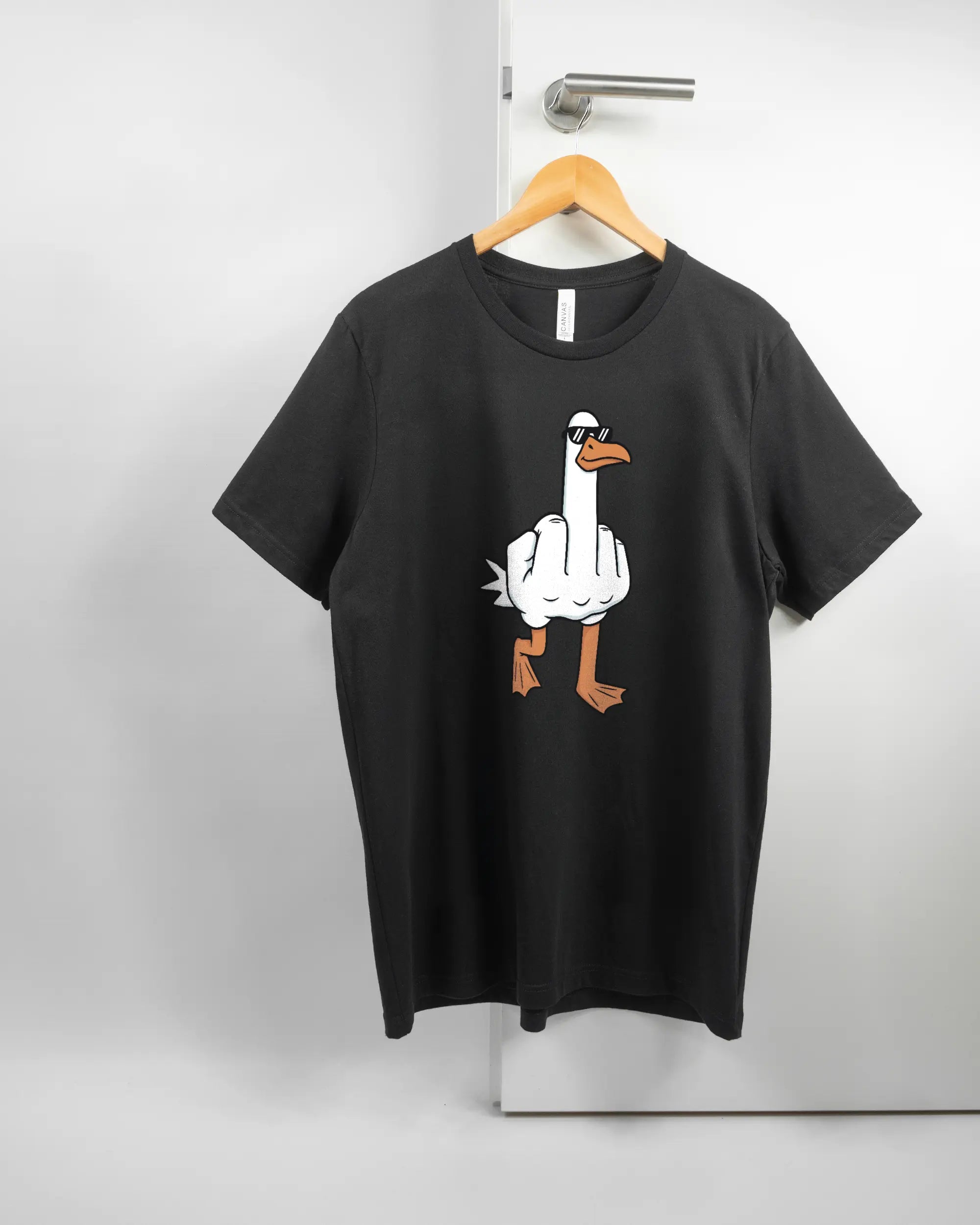 Vorderseite des Basic Unisex T-Shirt Light von Maondo mit dem Design I give a duck in der Farbe Black und in der Größe L auf einem Bügel an der Türklinke aufgehängt