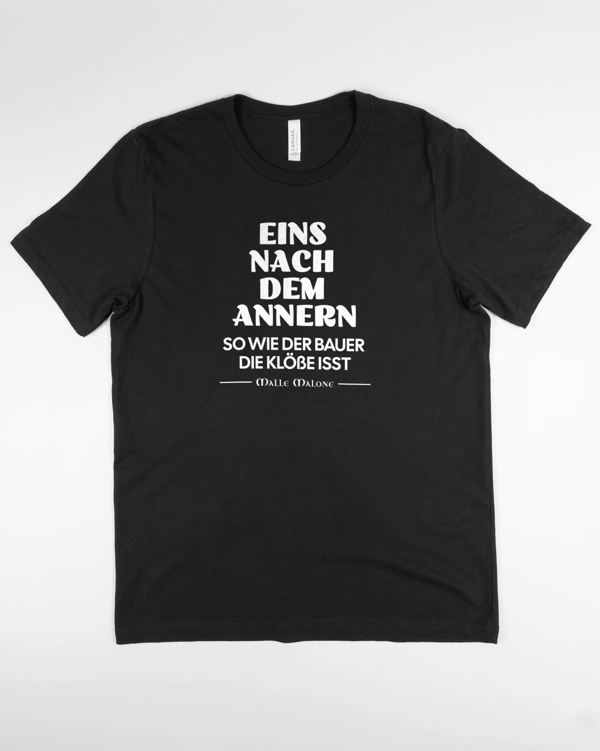Vorderseite des Basic Unisex T-Shirt Light von Maondo mit dem Design Eins nach dem Annern in der Farbe Black und in der Größe L flach auf den Boden gelegt