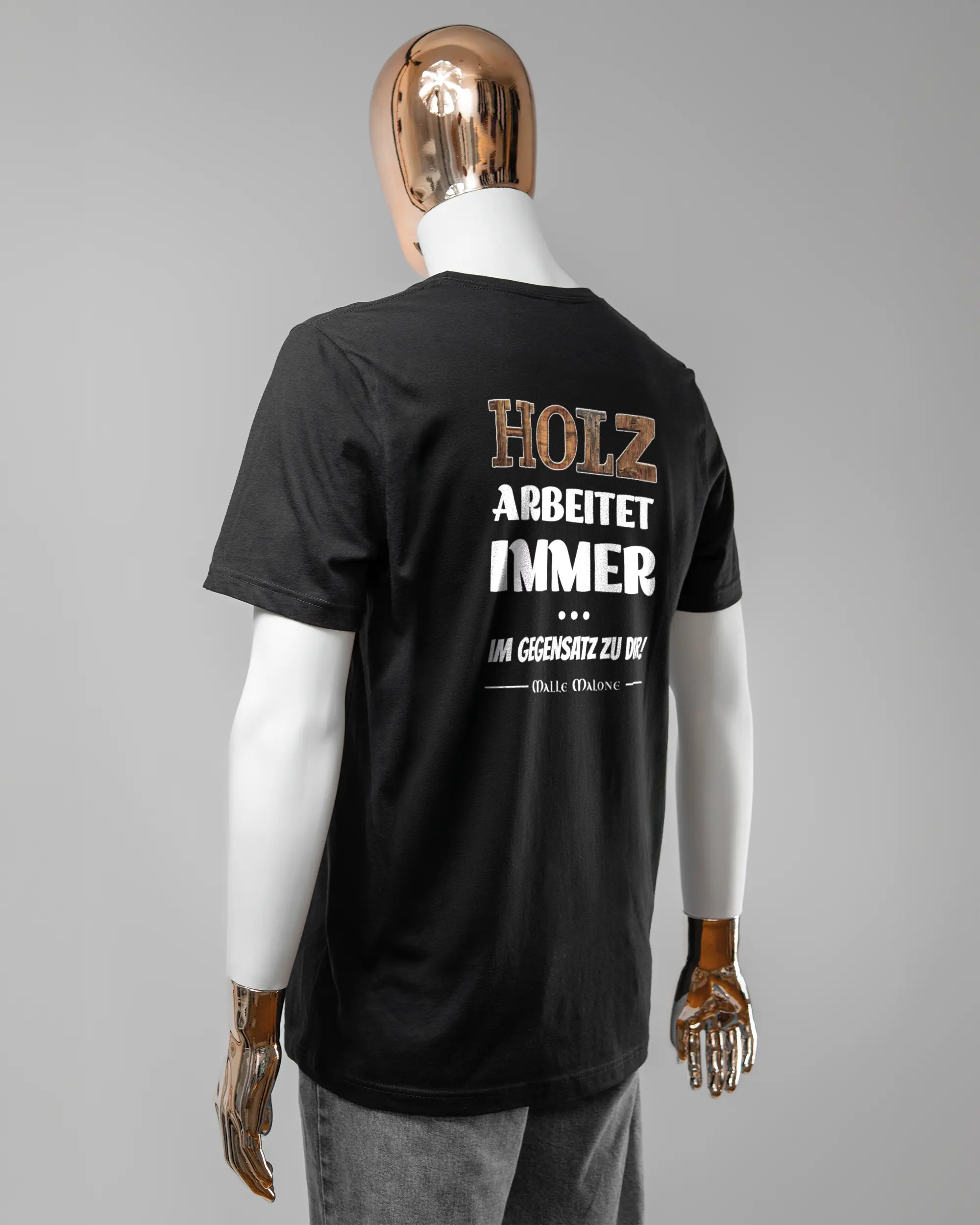 Rückseite des Basic Unisex T-Shirt Light von Maondo mit dem Design Holzarbeit in der Farbe Black und in der Größe L getragen von einer maskulinen Puppe
