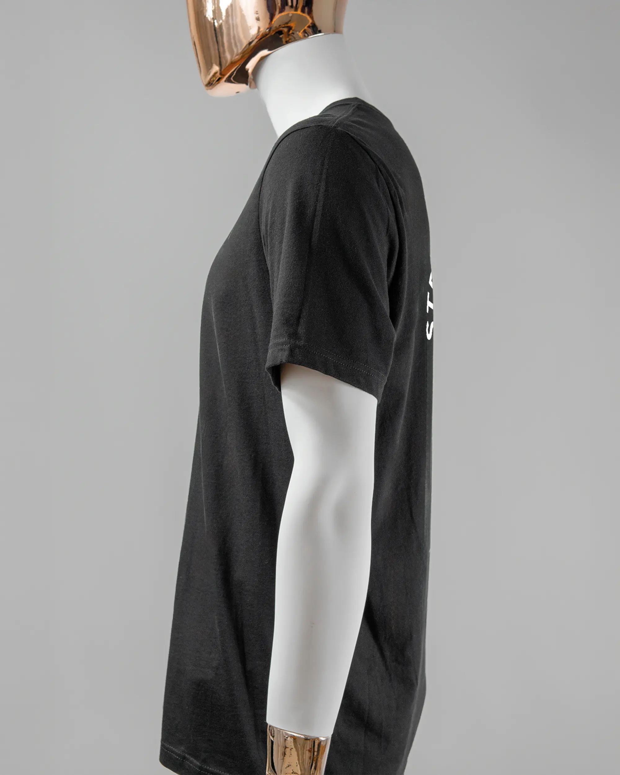 Seitenansicht des Basic Unisex T-Shirt Light von Maondo mit dem Design Brocco-Lee hinten in der Farbe Black und in der Größe L getragen von einer maskulinen Puppe