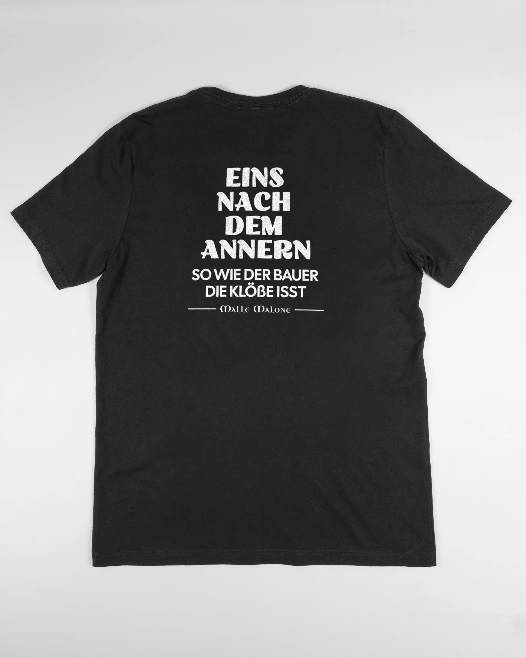 Rückseite des Basic Unisex T-Shirt Light von Maondo mit dem Design Eins nach dem Annern in der Farbe Black und in der Größe L flach auf den Boden gelegt