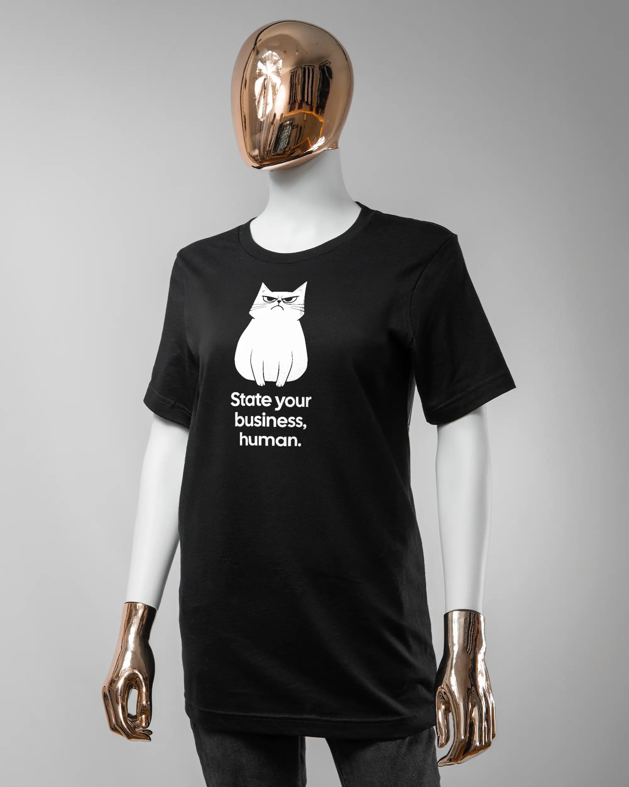 Vorderseite des Basic Unisex T-Shirt Light von Maondo mit dem Design Grumpy Purr in der Farbe Black und in der Größe S getragen von einer femininen Puppe