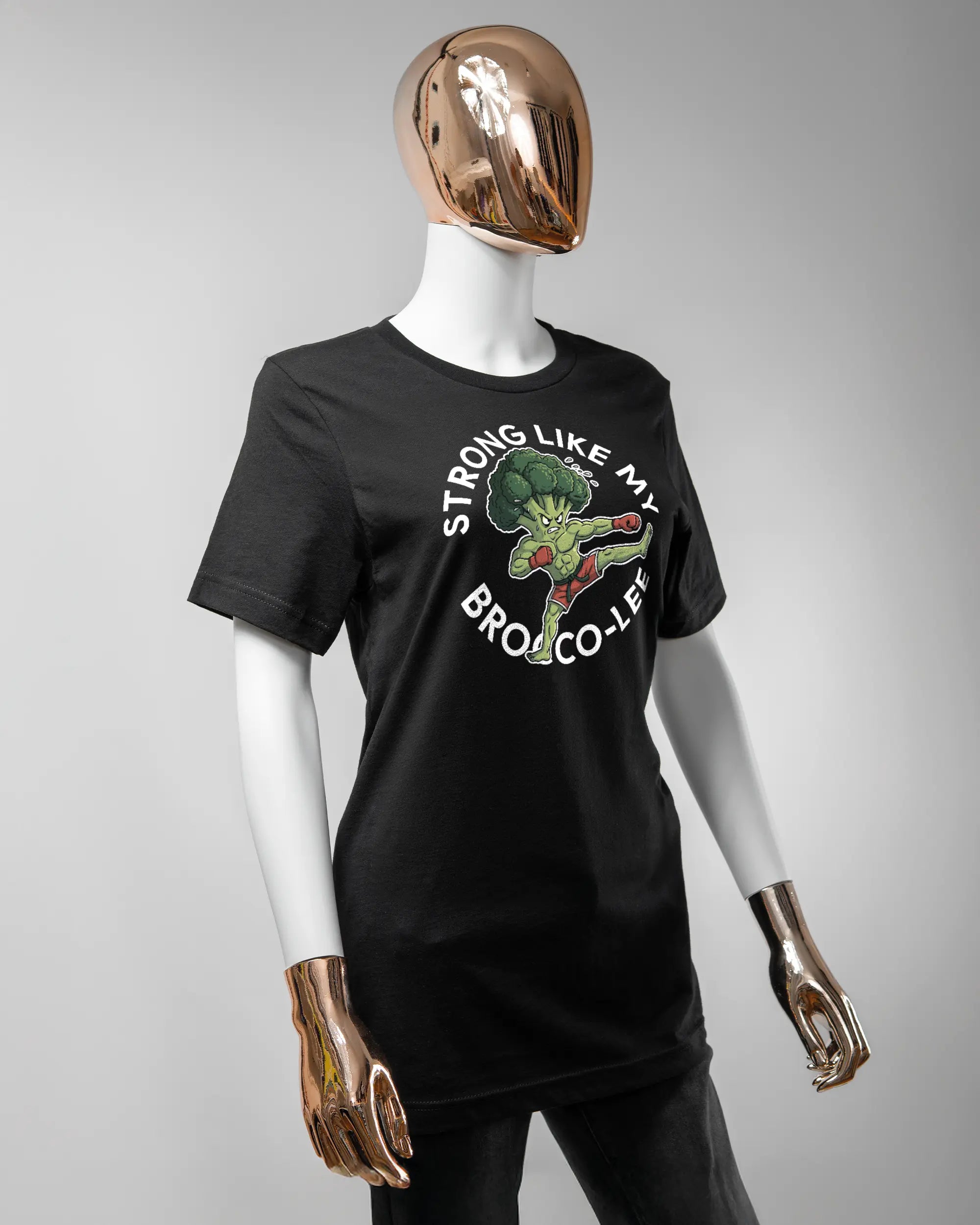 Vorderseite des Basic Unisex T-Shirt Light von Maondo mit dem Design Brocco-Lee in der Farbe Black und in der Größe S getragen von einer femininen Puppe