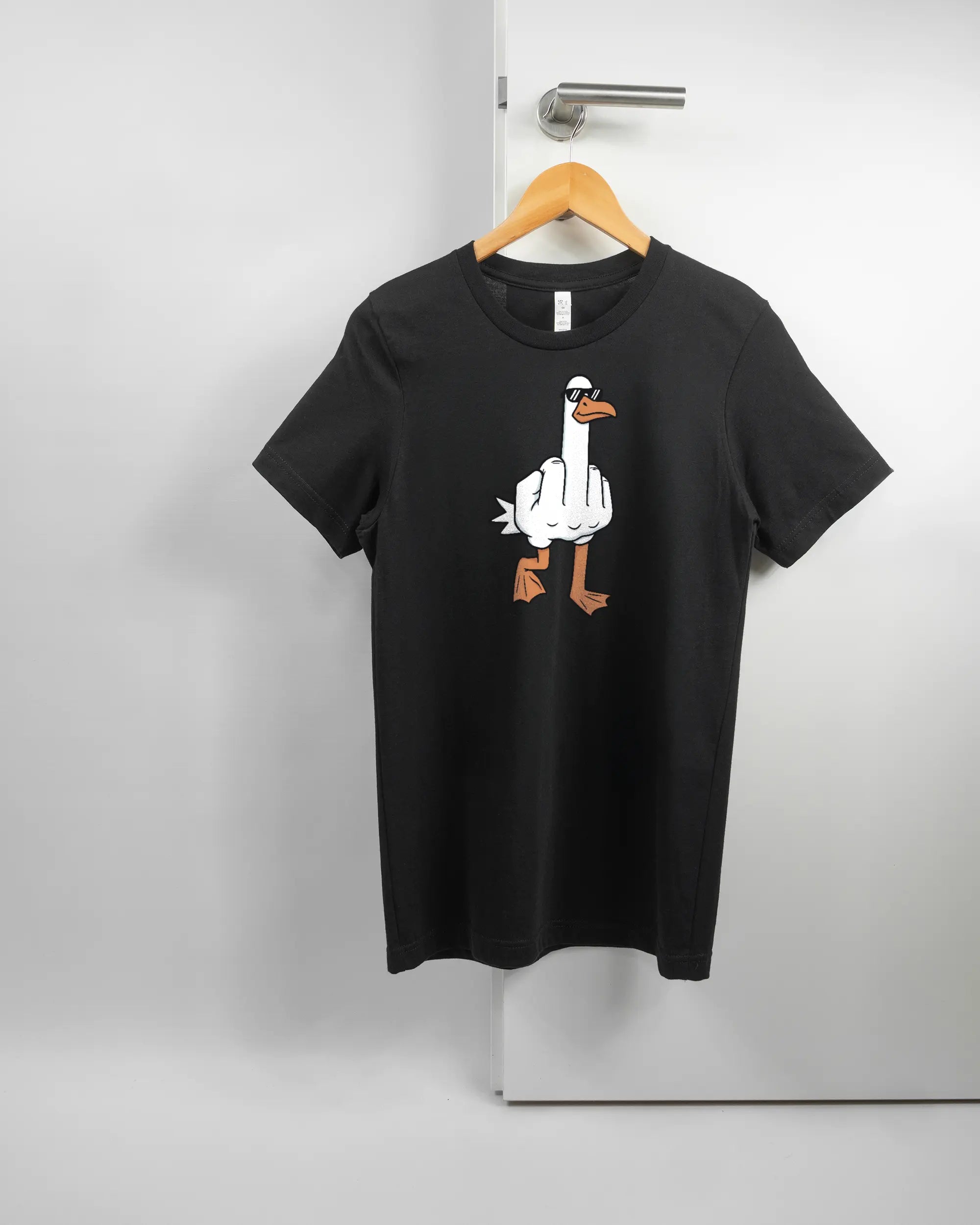 Vorderseite des Basic Unisex T-Shirt Light von Maondo mit dem Design I give a duck in der Farbe Black und in der Größe S auf einem Bügel an der Türklinke aufgehängt