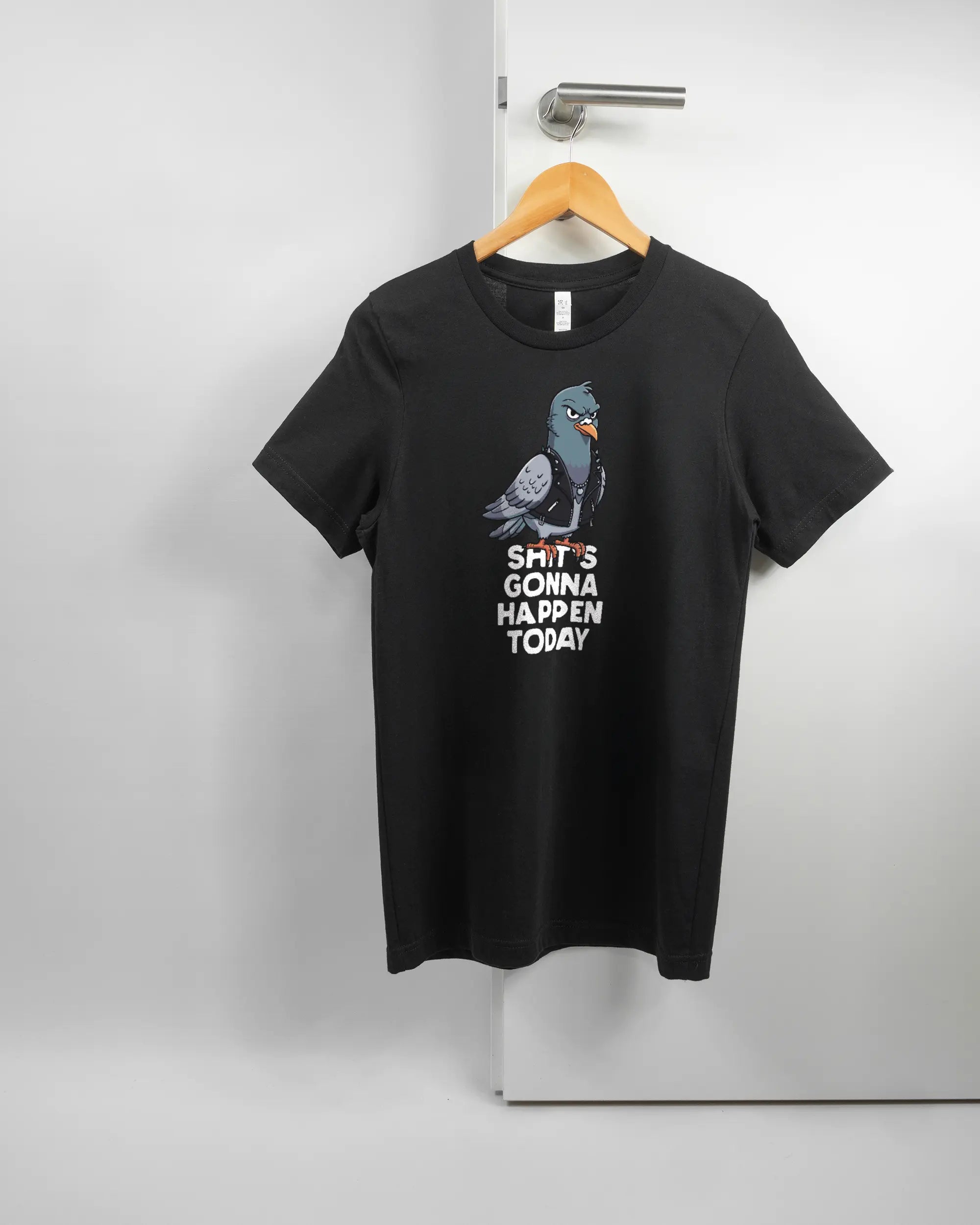 Vorderseite des Basic Unisex T-Shirt Light von Maondo mit dem Design Pigeon Pun in der Farbe Black und in der Größe S auf einem Bügel an der Türklinke aufgehängt