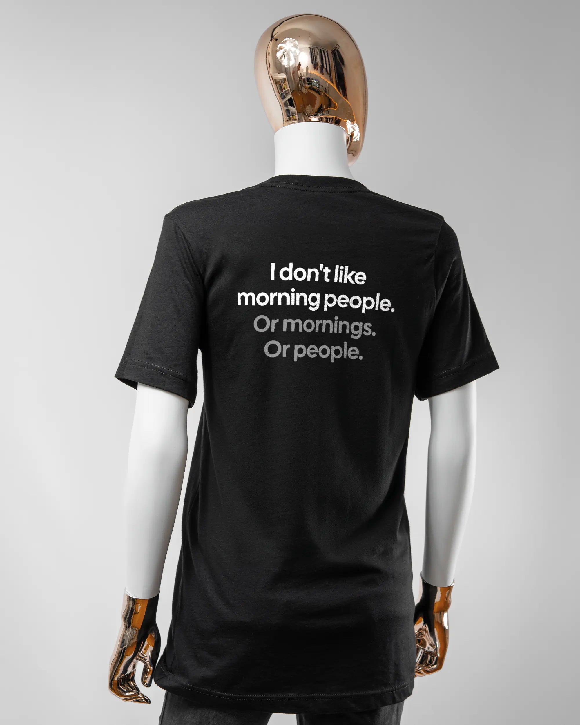 Rückseite des Basic Unisex T-Shirt Light von Maondo mit dem Design Morning Person in der Farbe Black und in der Größe S getragen von einer femininen Puppe