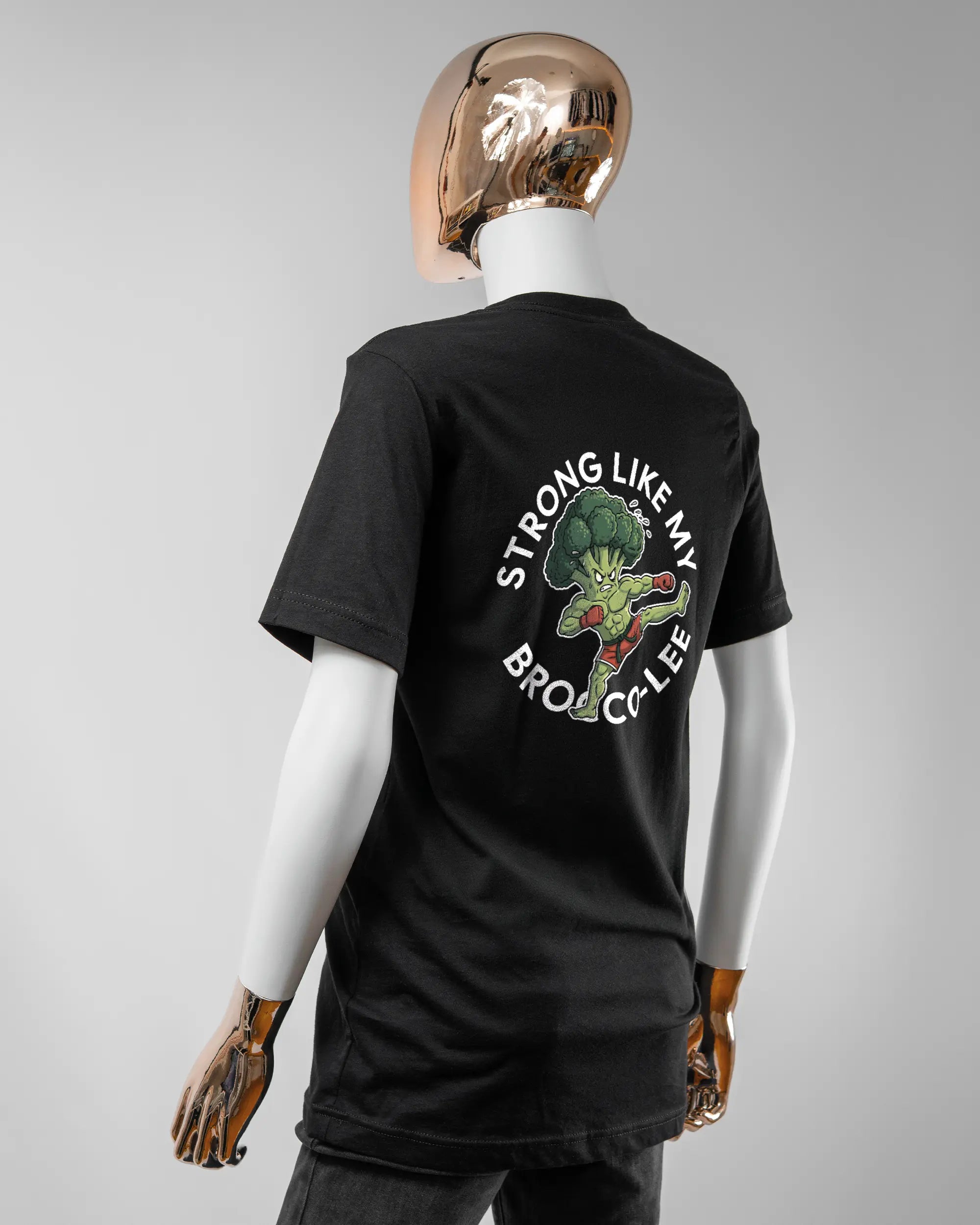 Rückseite des Basic Unisex T-Shirt Light von Maondo mit dem Design Brocco-Lee in der Farbe Black und in der Größe S getragen von einer femininen Puppe