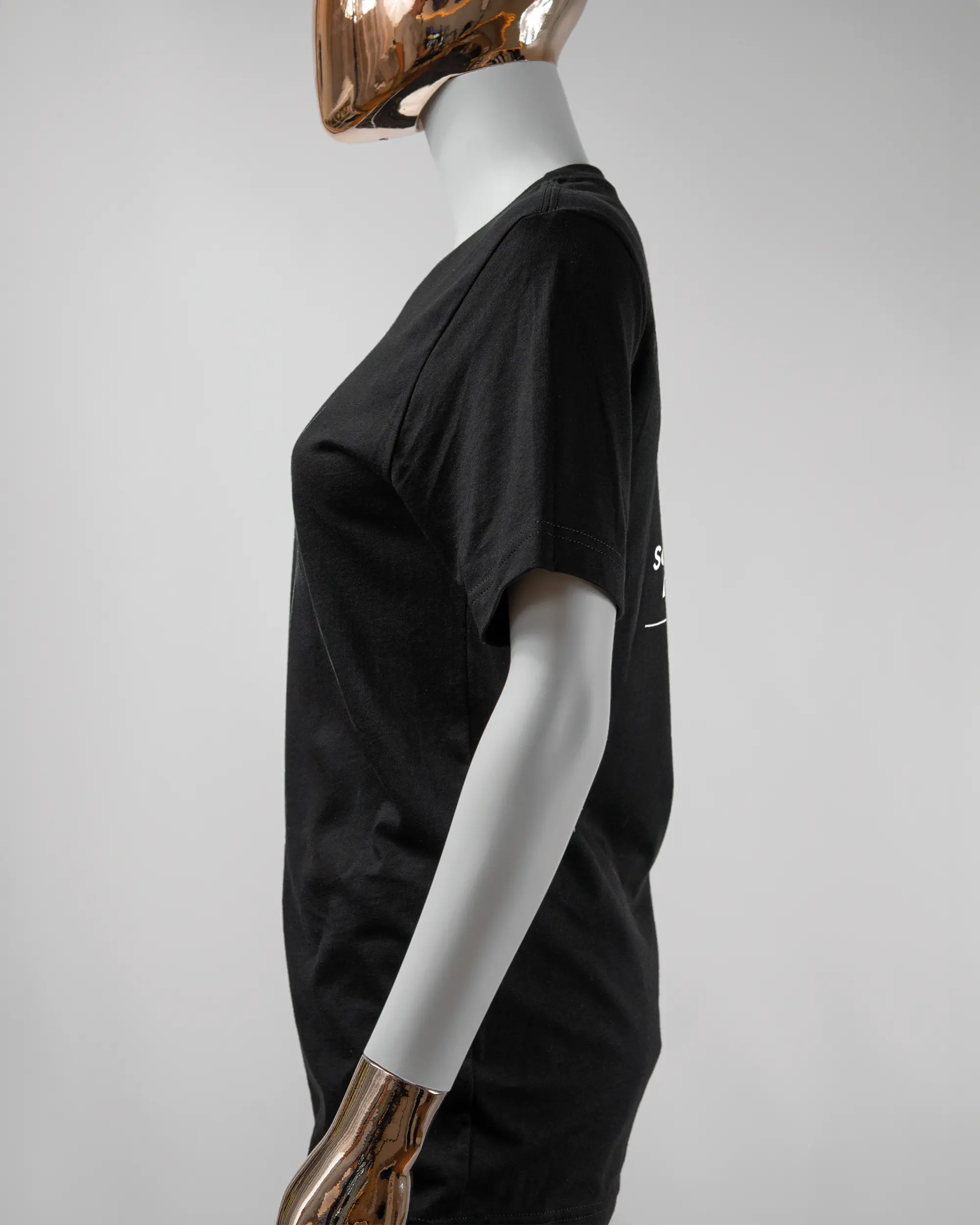 Seitenansicht des Basic Unisex T-Shirt Light von Maondo mit dem Design Eins nach dem Annern hinten in der Farbe Black und in der Größe S getragen von einer femininen Puppe