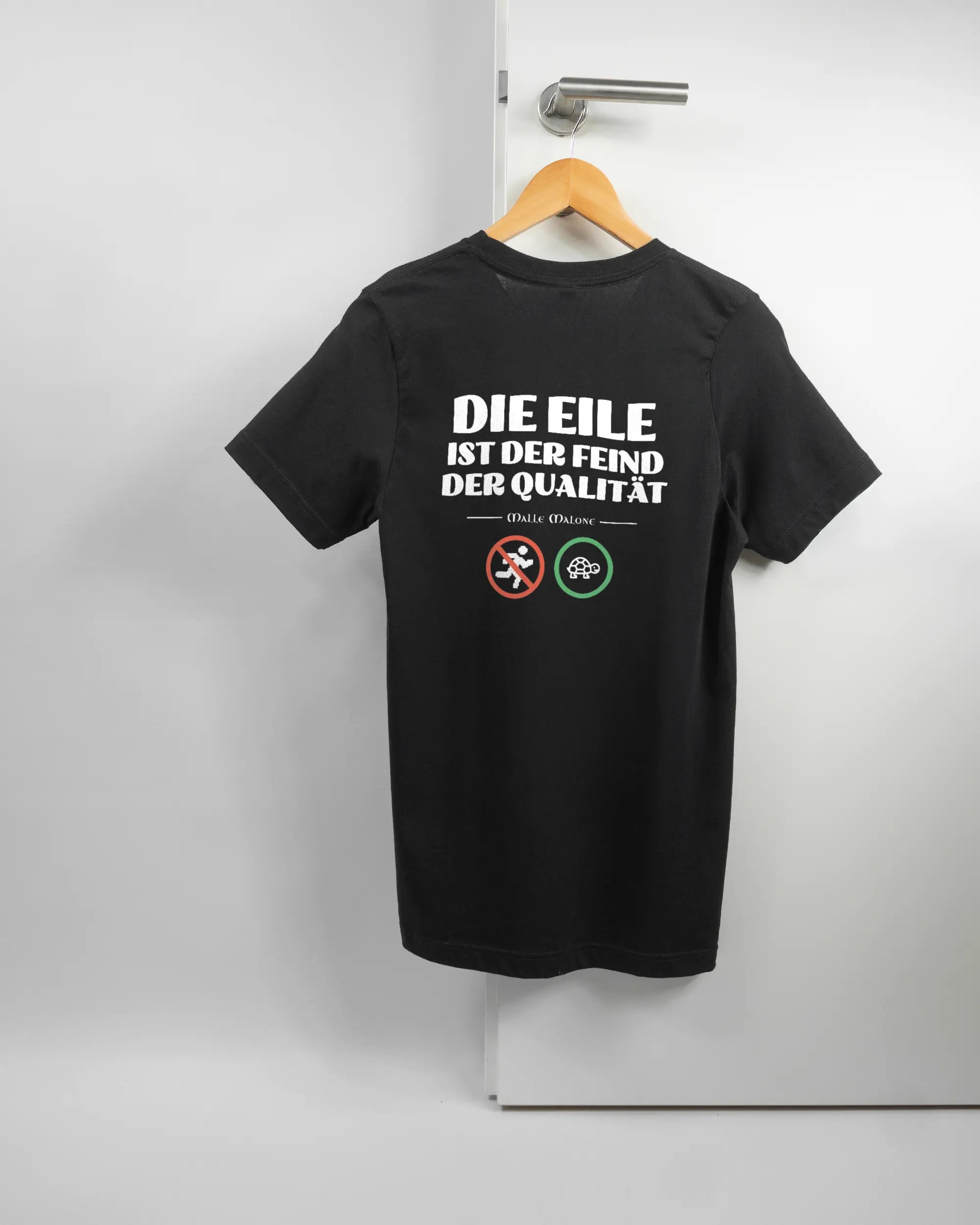 Rückseite des Basic Unisex T-Shirt Light von Maondo mit dem Design Keine Eile in der Farbe Black und in der Größe S auf einem Bügel an der Türklinke aufgehängt