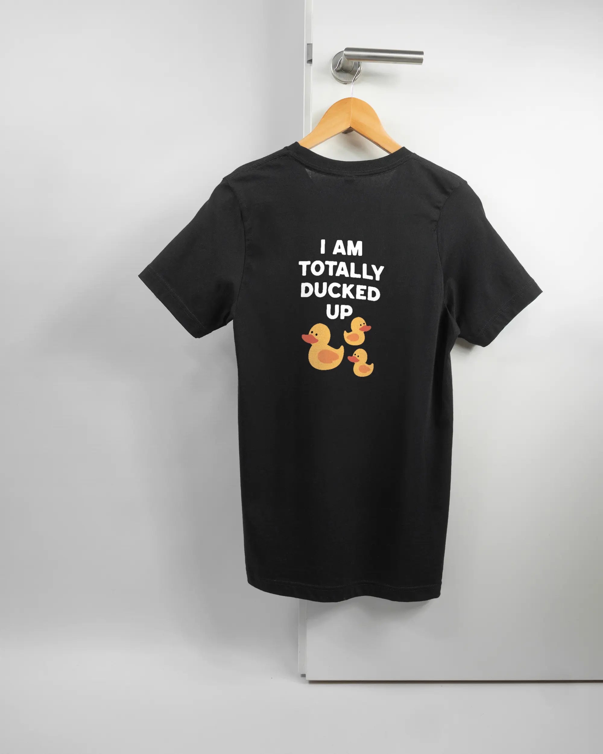 Rückseite des Basic Unisex T-Shirt Light von Maondo mit dem Design Ducked Up in der Farbe Black und in der Größe S auf einem Bügel an der Türklinke aufgehängt