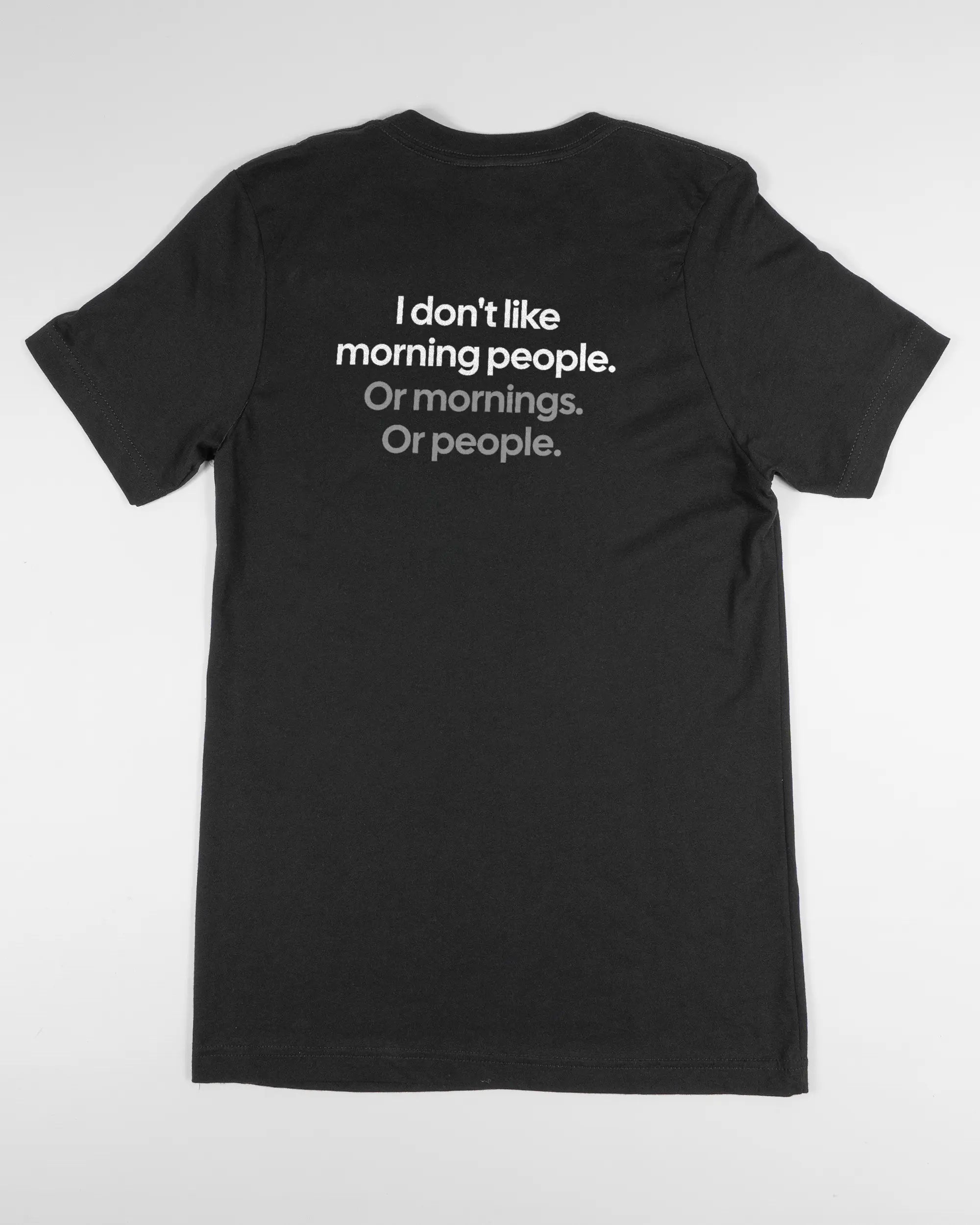 Rückseite des Basic Unisex T-Shirt Light von Maondo mit dem Design Morning Person in der Farbe Black und in der Größe S flach auf den Boden gelegt