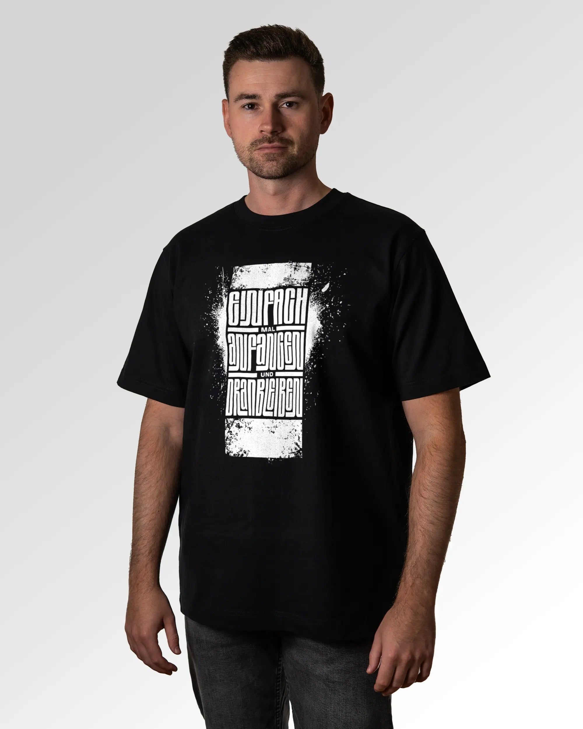 Primärer Modelshot der Druckseite des Organic Unisex T-Shirts von Maondo im Oversized Fit mit dem Design Einfach Anfangen in der Farbe Black