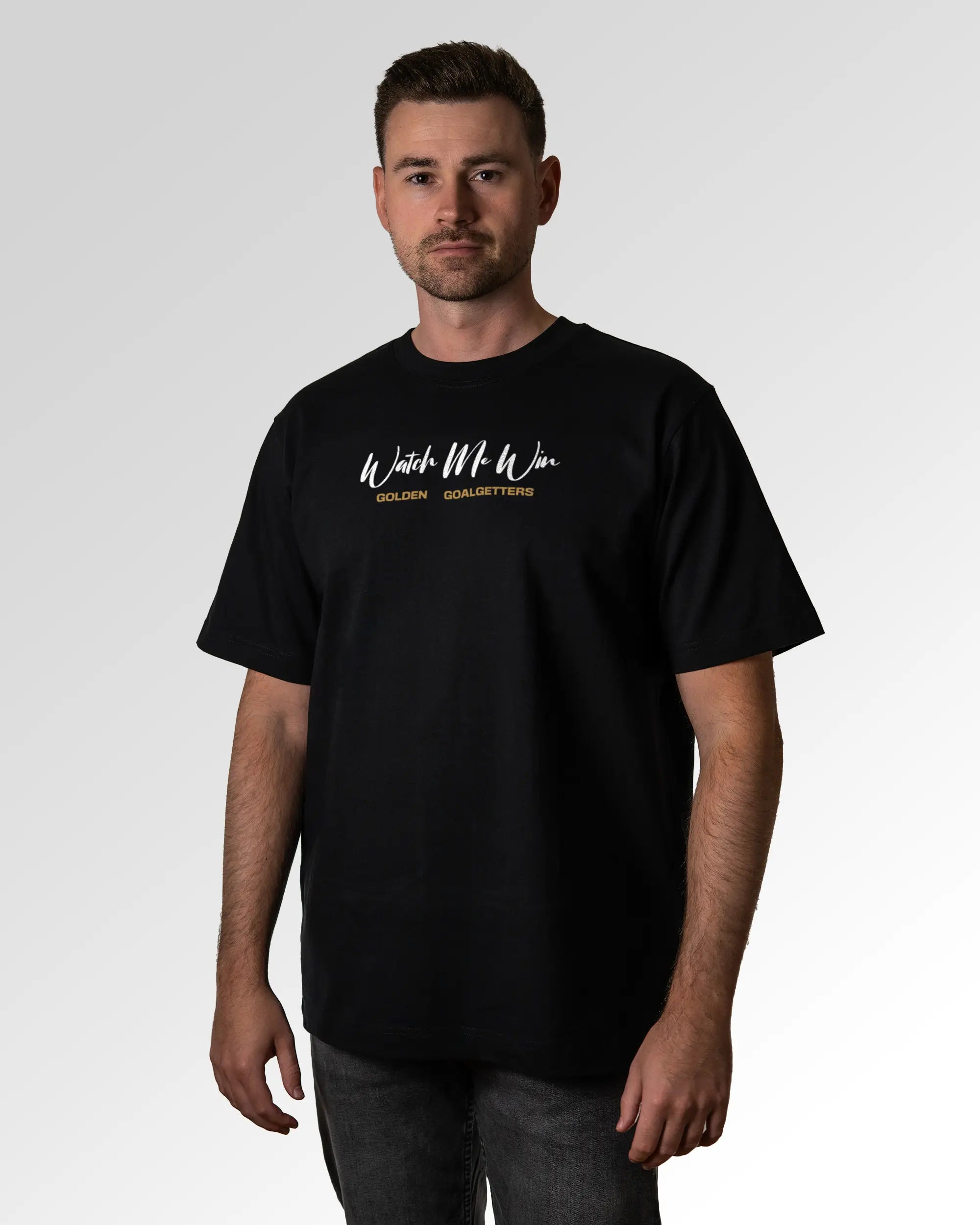 Männlicher Modelshot der primären Druckseite des Organic Unisex T-Shirts von Maondo im Oversized Fit mit dem Design Golden Goalgetters in der Farbe Black