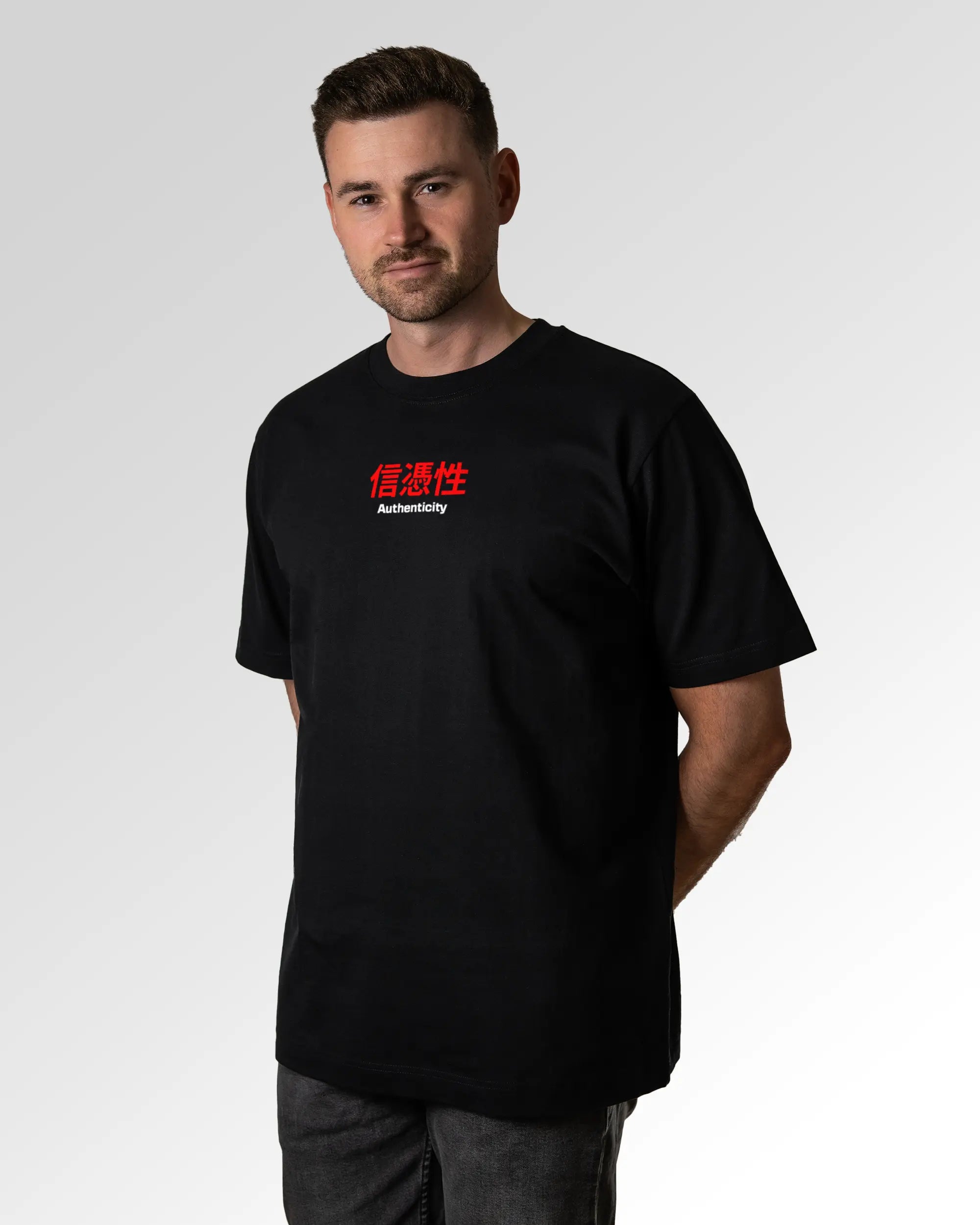 Männlicher Modelshot der primären Druckseite des Organic Unisex T-Shirts von Maondo im Oversized Fit mit dem Design Authentic Shit in der Farbe Black