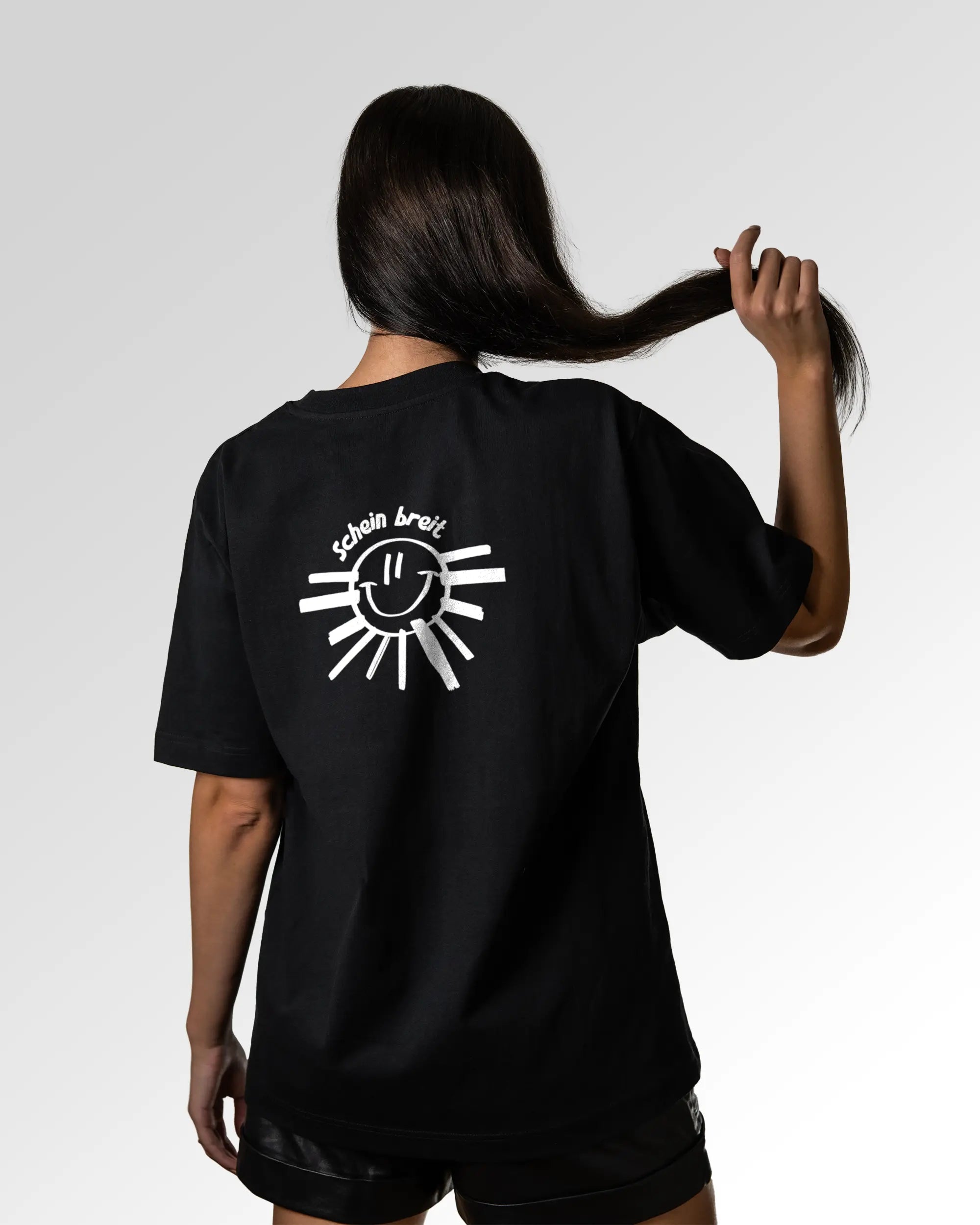 Sekundärer Modelshot der Druckseite des Organic Unisex T-Shirts von Maondo im Oversized Fit mit dem Design Schein Breit in der Farbe Black