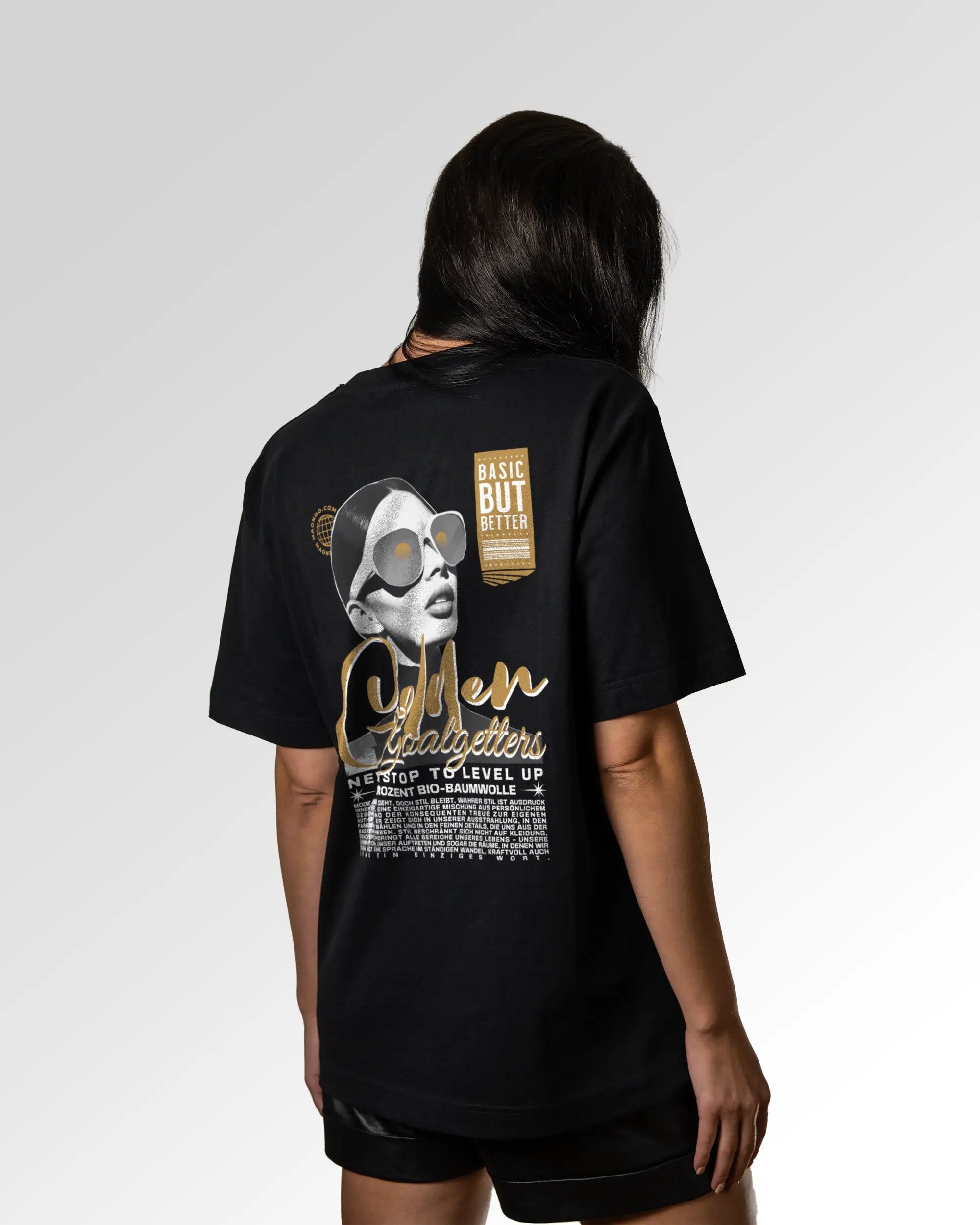 Weiblicher Modelshot der sekundären Druckseite des Organic Unisex T-Shirts von Maondo im Oversized Fit mit dem Design Golden Goalgetters in der Farbe Black
