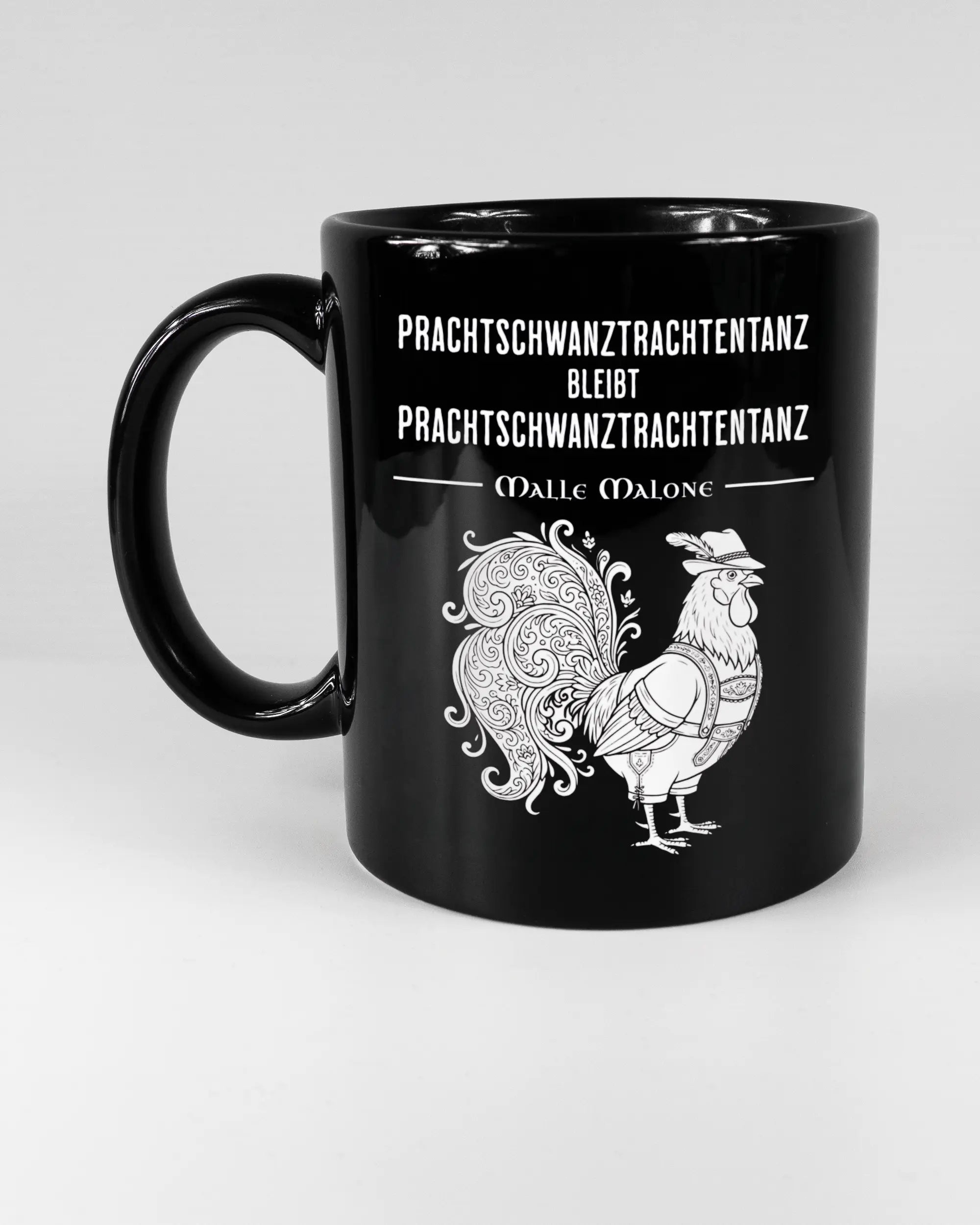 Titelbild, das die linke Seite der beidseitig bedruckten Keramiktasse von Maondo mit dem Design Trachtentanz in der Farbe Black auf einem Holztisch zeigt