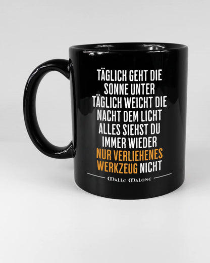 Titelbild, das die linke Seite der beidseitig bedruckten Keramiktasse von Maondo mit dem Design Wegzeug in der Farbe Black auf einem Holztisch zeigt