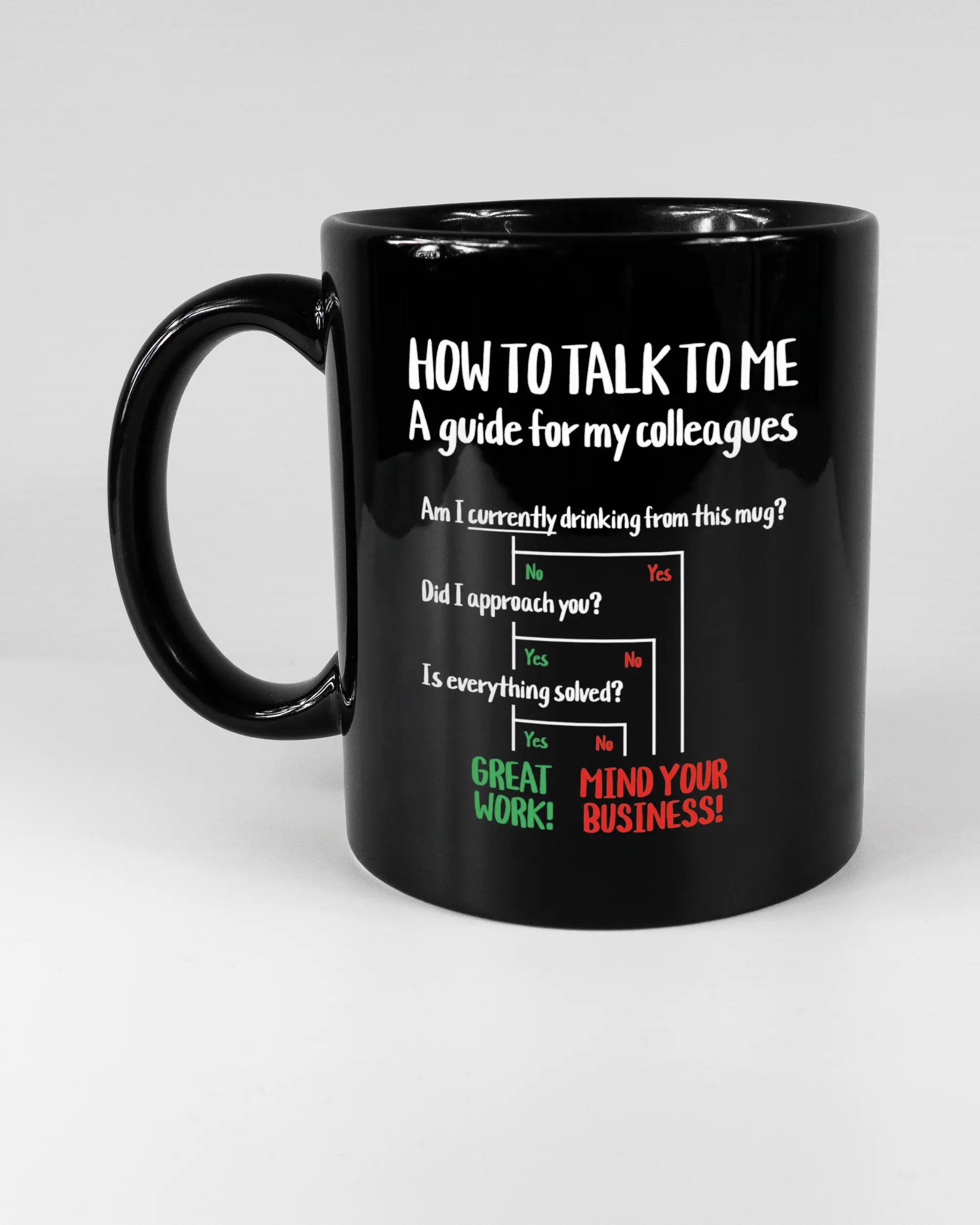 Titelbild, das die linke Seite der beidseitig bedruckten Keramiktasse von Maondo mit dem Design Colleagues Guide in der Farbe Black auf einem Holztisch zeigt