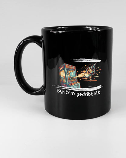 Titelbild, das die linke Seite der beidseitig bedruckten Keramiktasse von Maondo mit dem Design System gedribbelt in der Farbe Black auf einem Holztisch zeigt