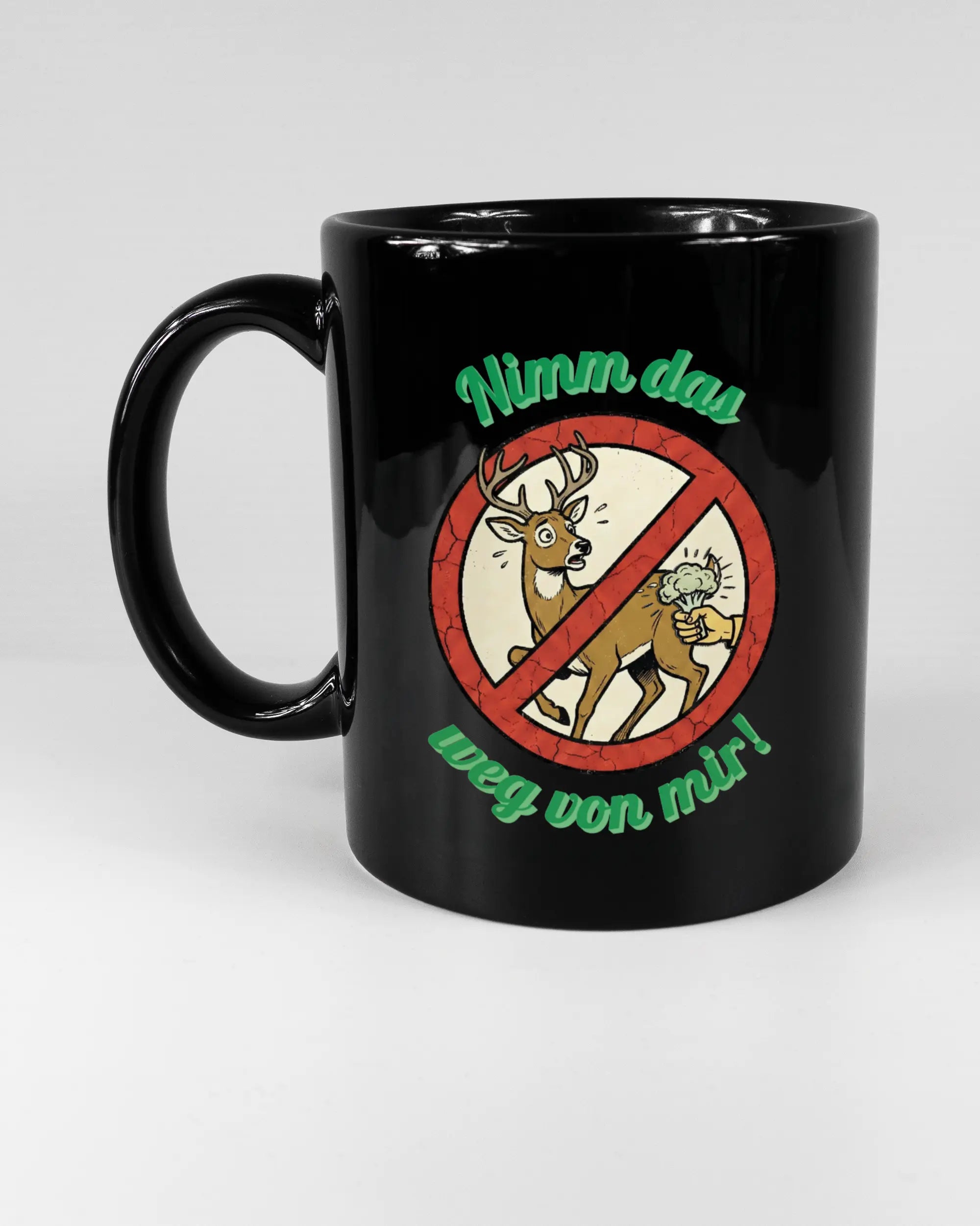 Titelbild, das die linke Seite der beidseitig bedruckten Keramiktasse von Maondo mit dem Design Reh weg in der Farbe Black auf einem Holztisch zeigt