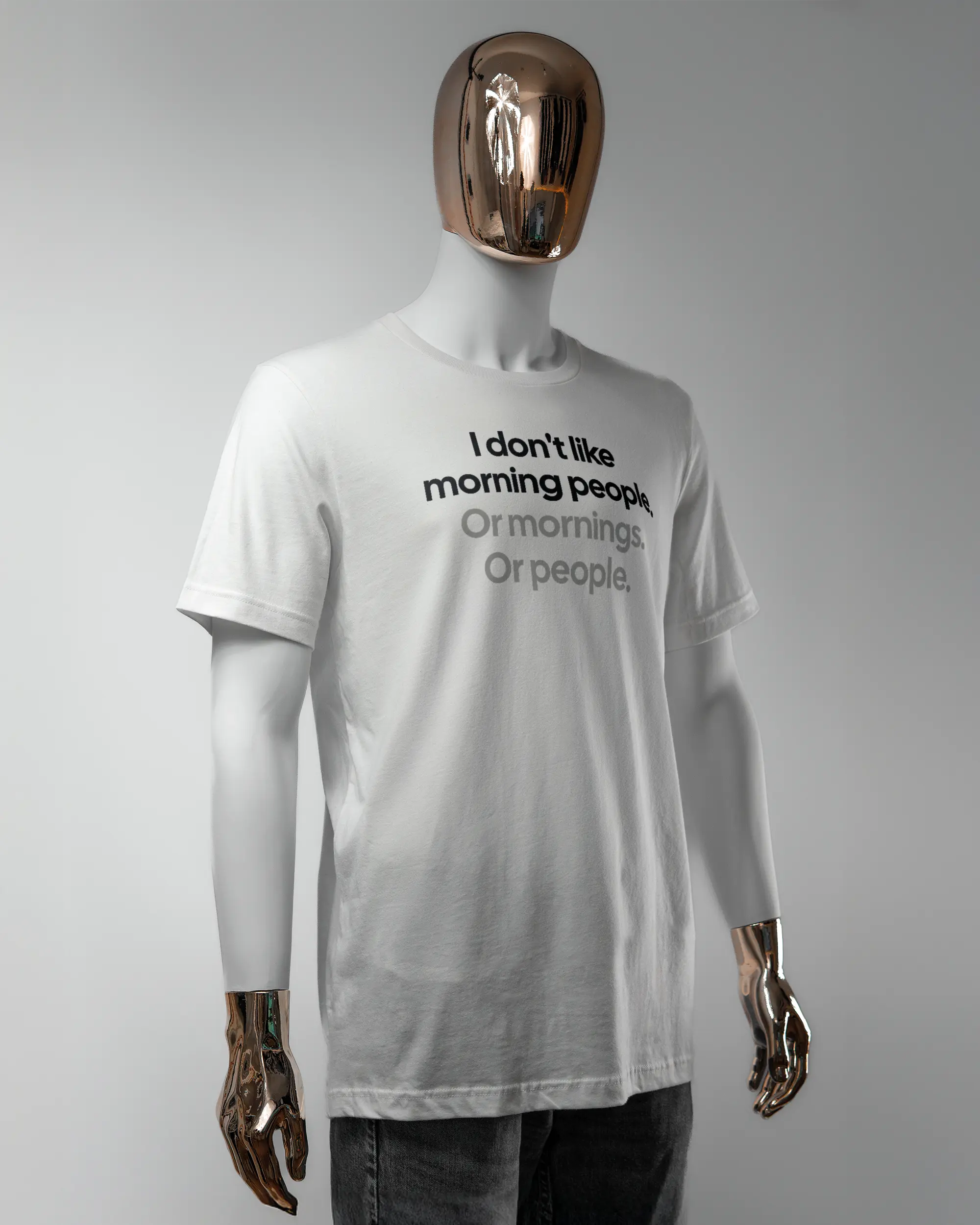 Vorderseite des Basic Unisex T-Shirt Light von Maondo mit dem Design Morning Person in der Farbe White und in der Größe L getragen von einer maskulinen Puppe