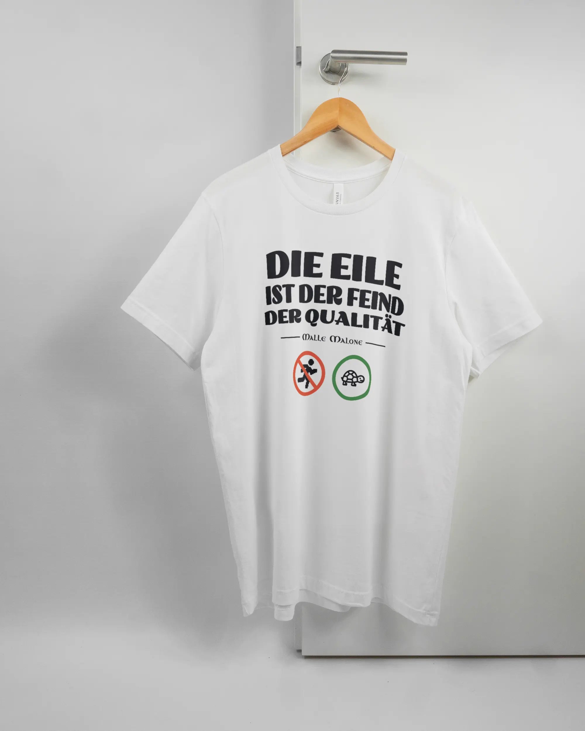 Vorderseite des Basic Unisex T-Shirt Light von Maondo mit dem Design Keine Eile in der Farbe White und in der Größe L auf einem Bügel an der Türklinke aufgehängt