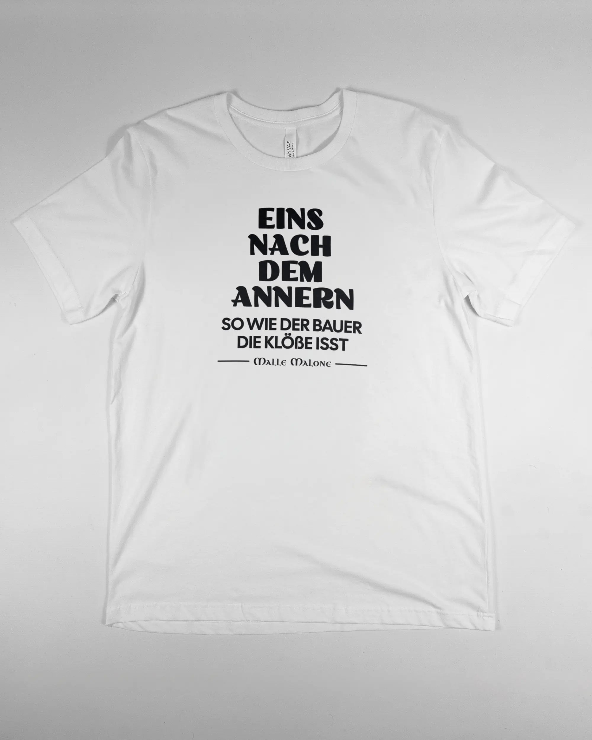 Vorderseite des Basic Unisex T-Shirt Light von Maondo mit dem Design Eins nach dem Annern in der Farbe White und in der Größe L flach auf den Boden gelegt