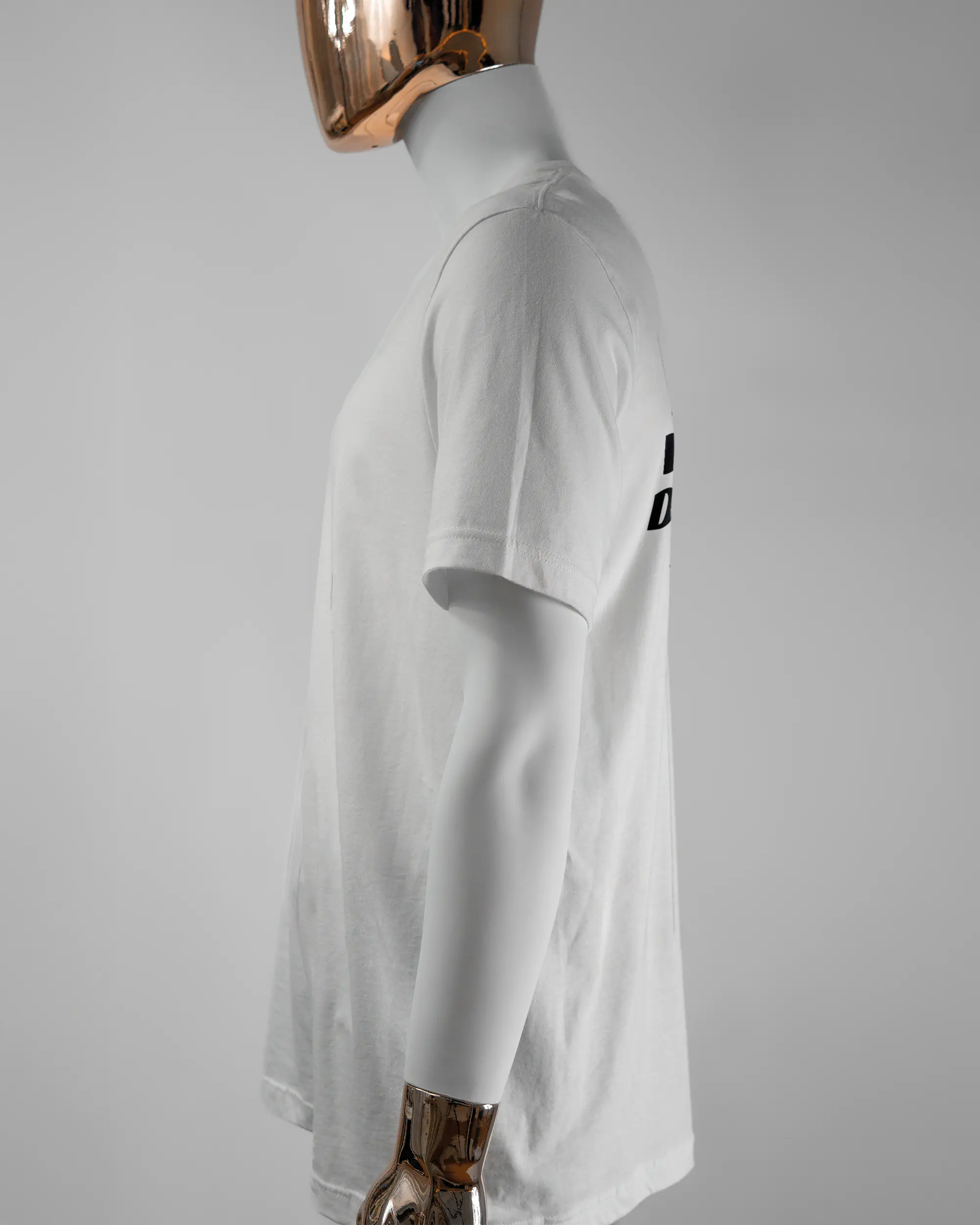 Seitenansicht des Basic Unisex T-Shirt Light von Maondo mit dem Design Keine Eile hinten in der Farbe White und in der Größe L getragen von einer maskulinen Puppe