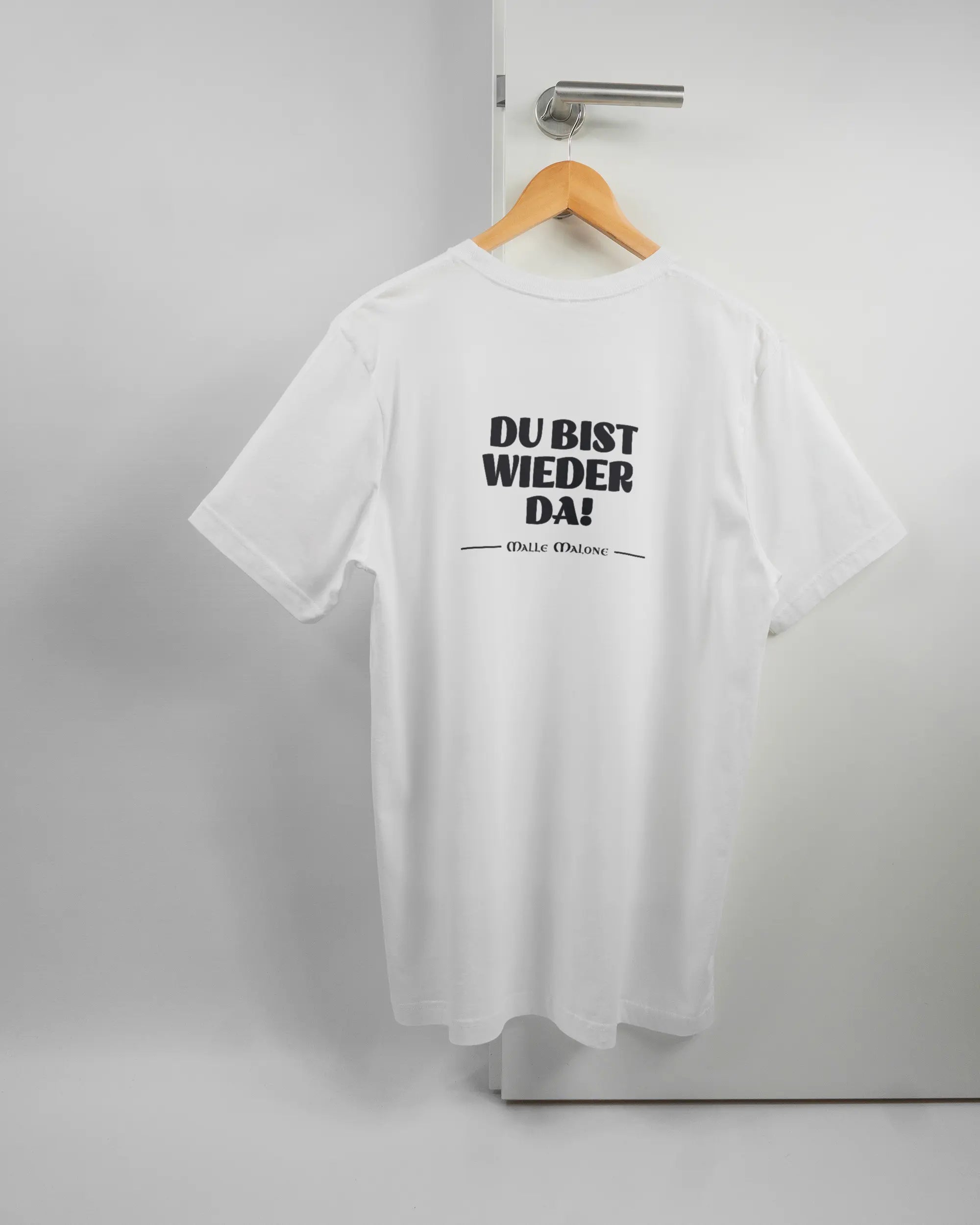 Rückseite des Basic Unisex T-Shirt Light von Maondo mit dem Design Wieder da in der Farbe White und in der Größe L auf einem Bügel an der Türklinke aufgehängt
