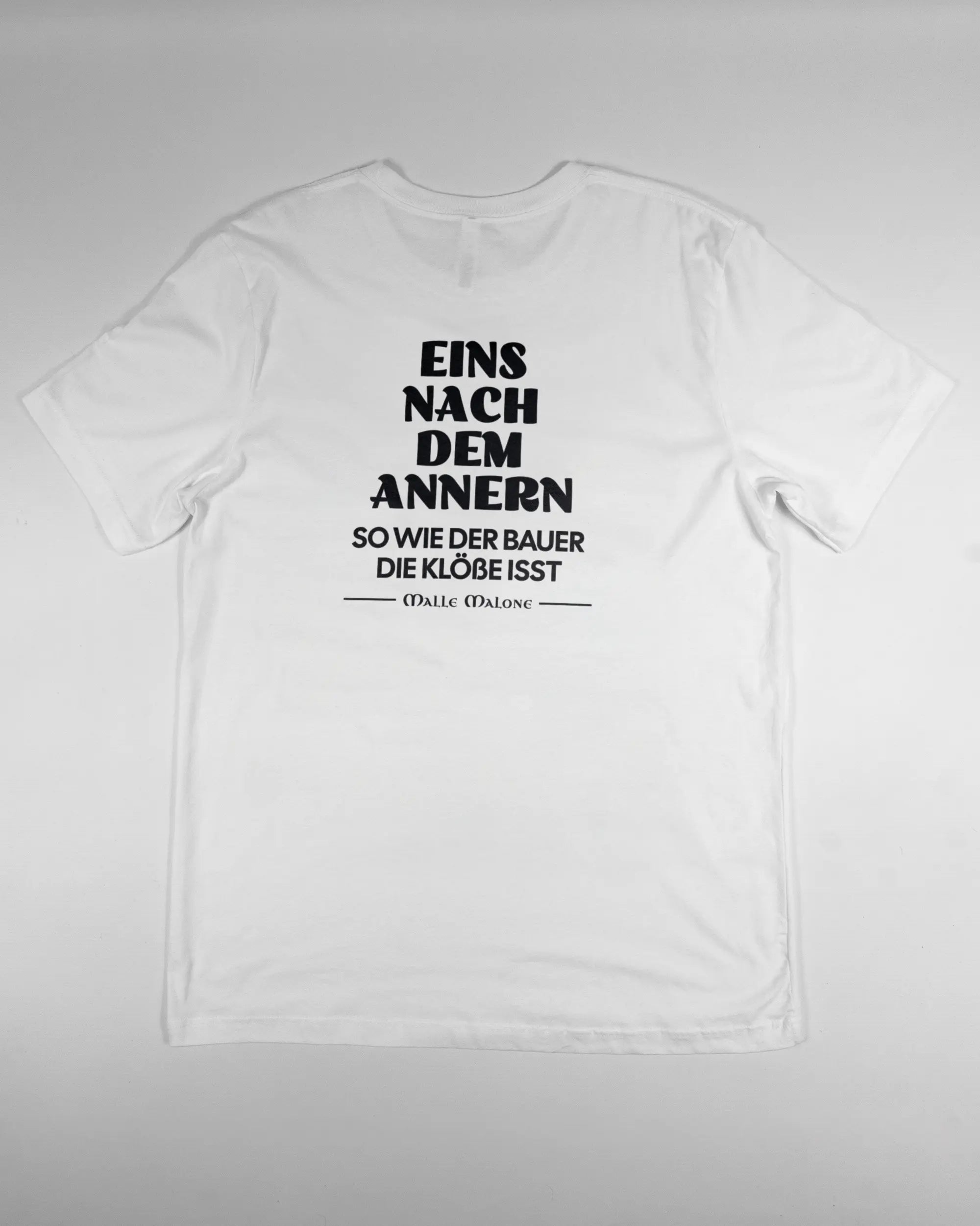 Rückseite des Basic Unisex T-Shirt Light von Maondo mit dem Design Eins nach dem Annern in der Farbe White und in der Größe L flach auf den Boden gelegt