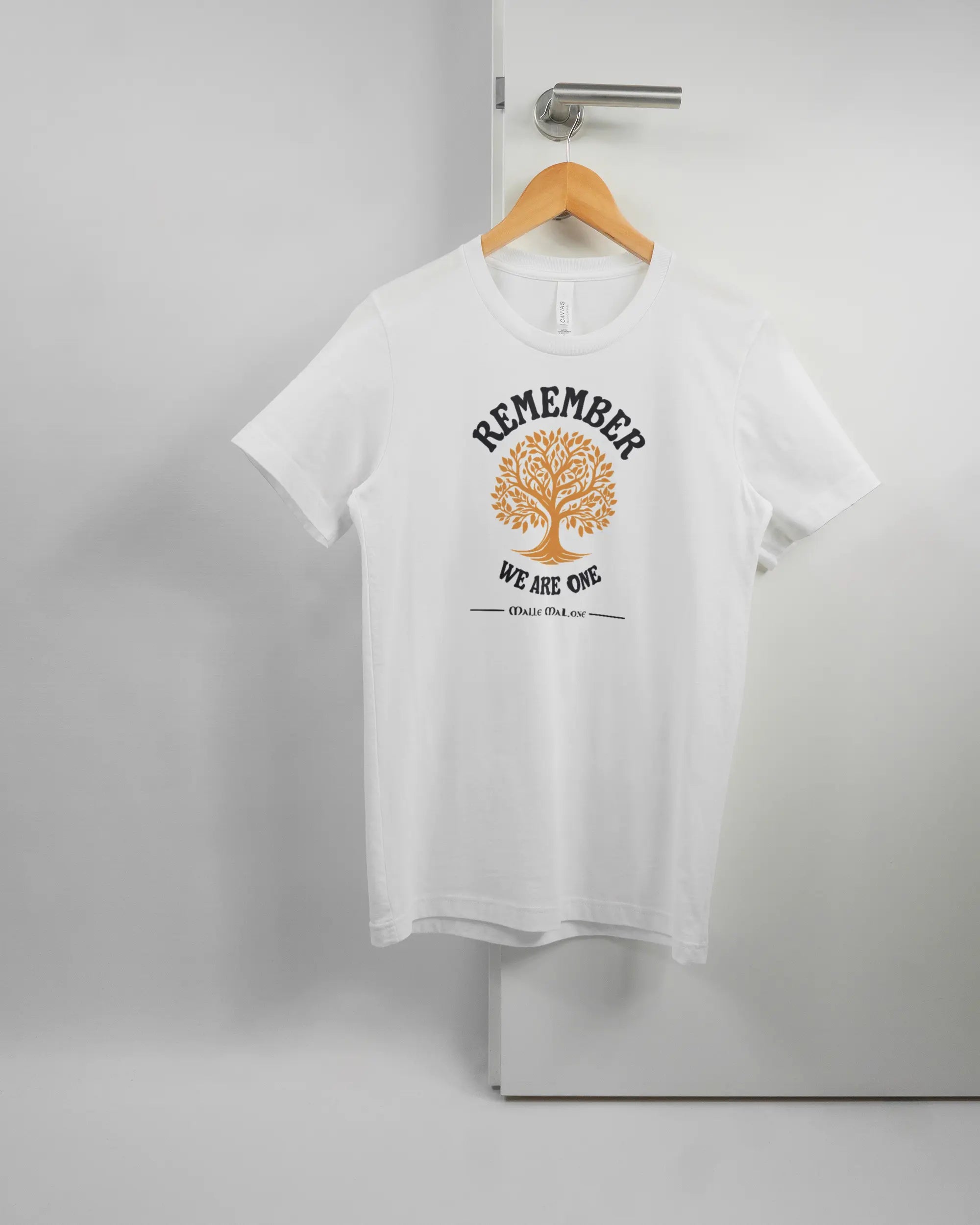Vorderseite des Basic Unisex T-Shirt Light von Maondo mit dem Design We are one in der Farbe White und in der Größe S auf einem Bügel an der Türklinke aufgehängt
