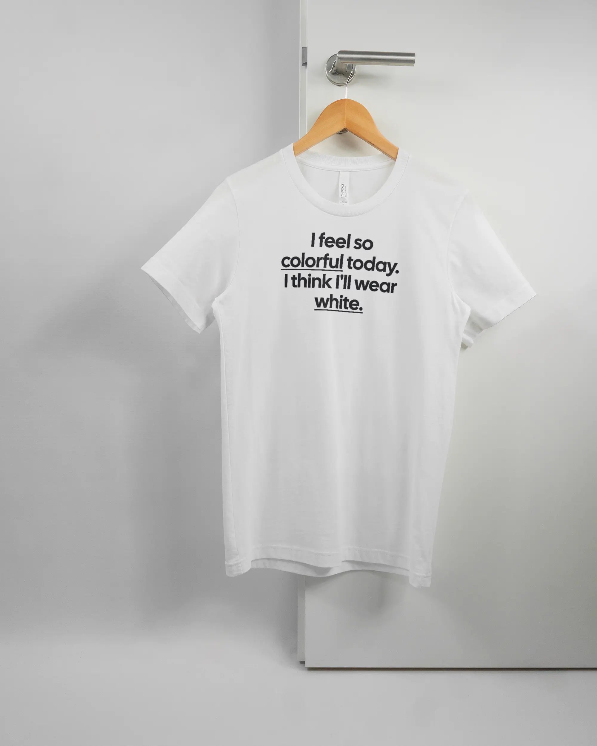 Vorderseite des Basic Unisex T-Shirt Light von Maondo mit dem Design Colorful Day in der Farbe White und in der Größe S auf einem Bügel an der Türklinke aufgehängt