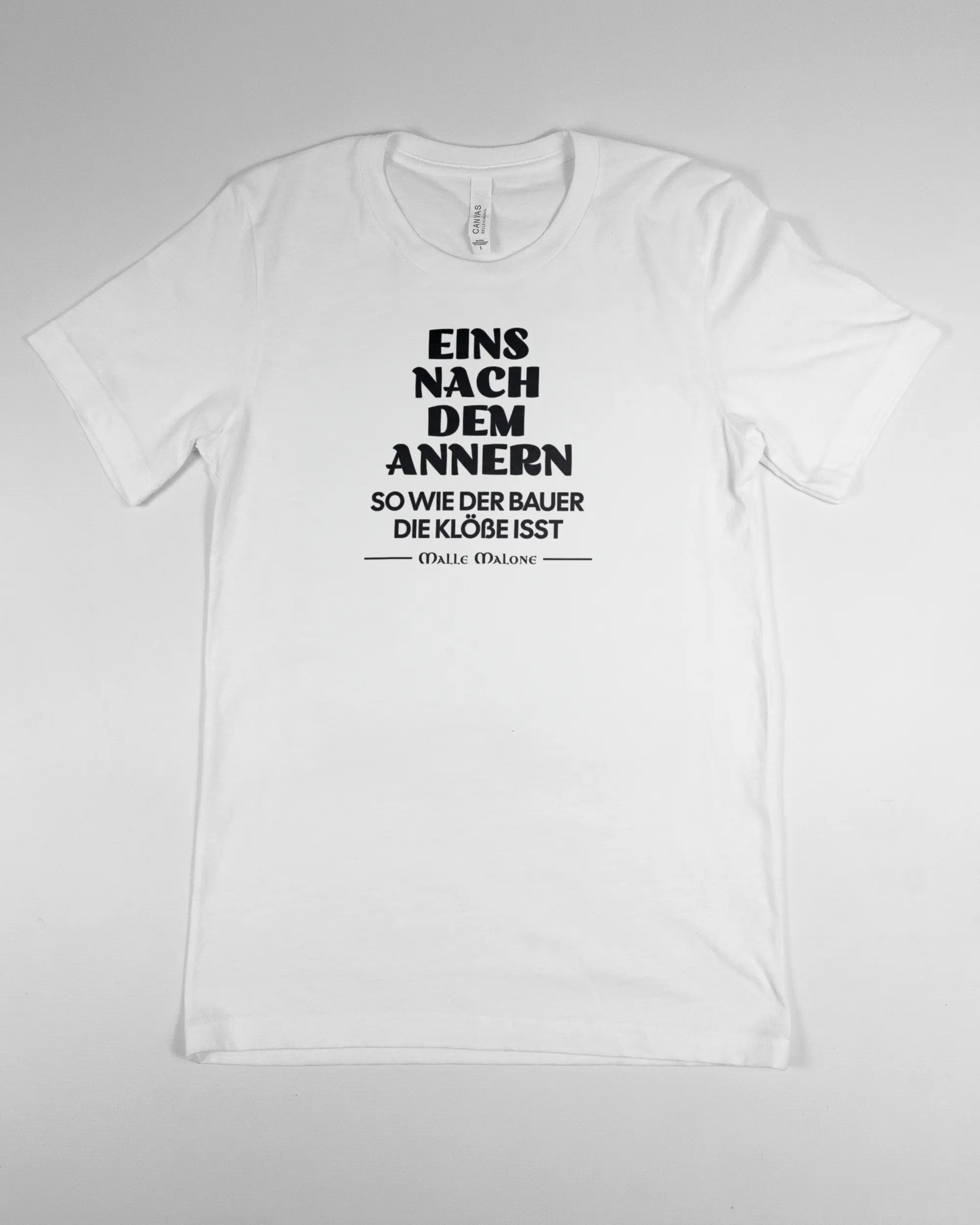 Vorderseite des Basic Unisex T-Shirt Light von Maondo mit dem Design Eins nach dem Annern in der Farbe White und in der Größe S flach auf den Boden gelegt