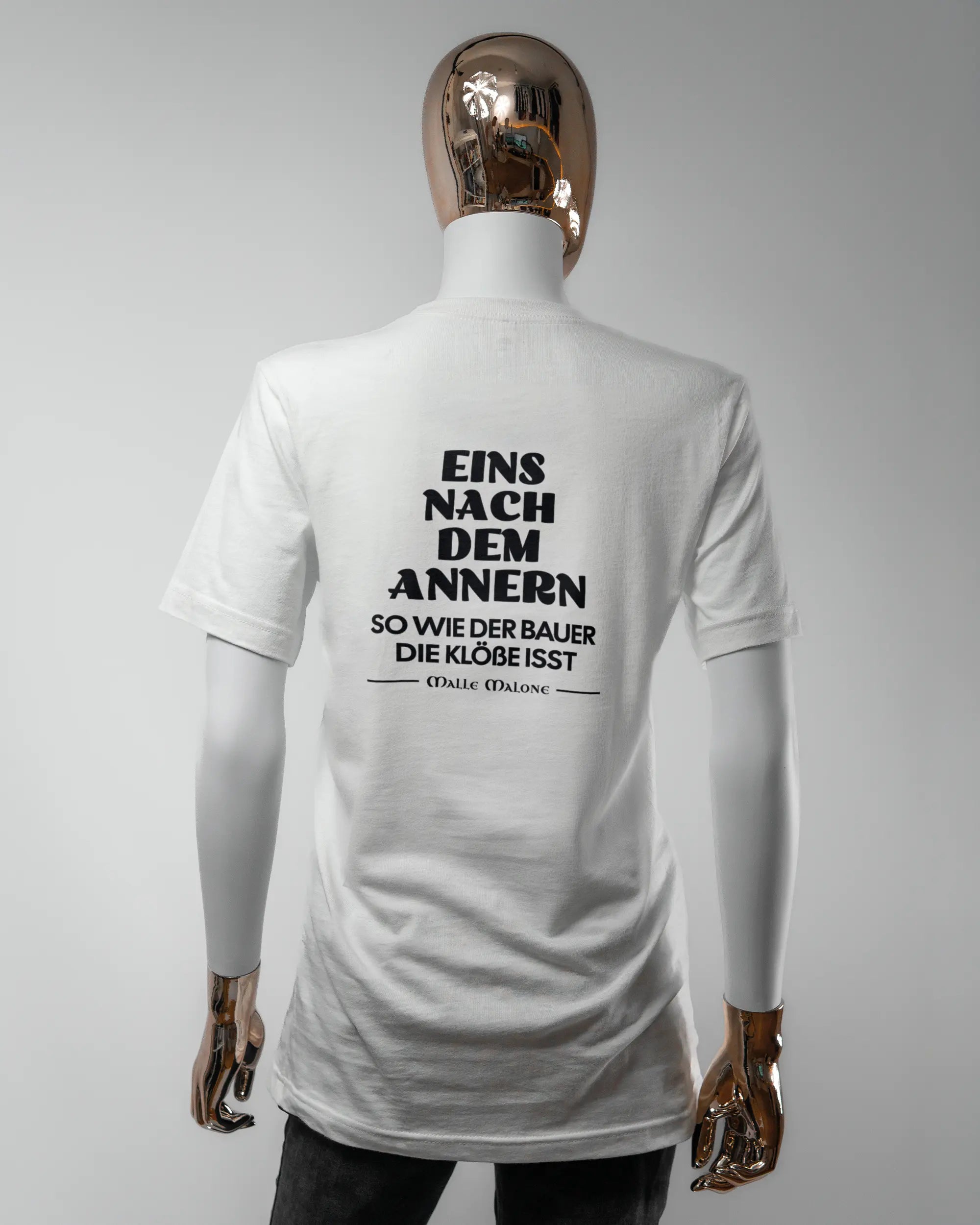 Rückseite des Basic Unisex T-Shirt Light von Maondo mit dem Design Eins nach dem Annern in der Farbe White und in der Größe S getragen von einer femininen Puppe