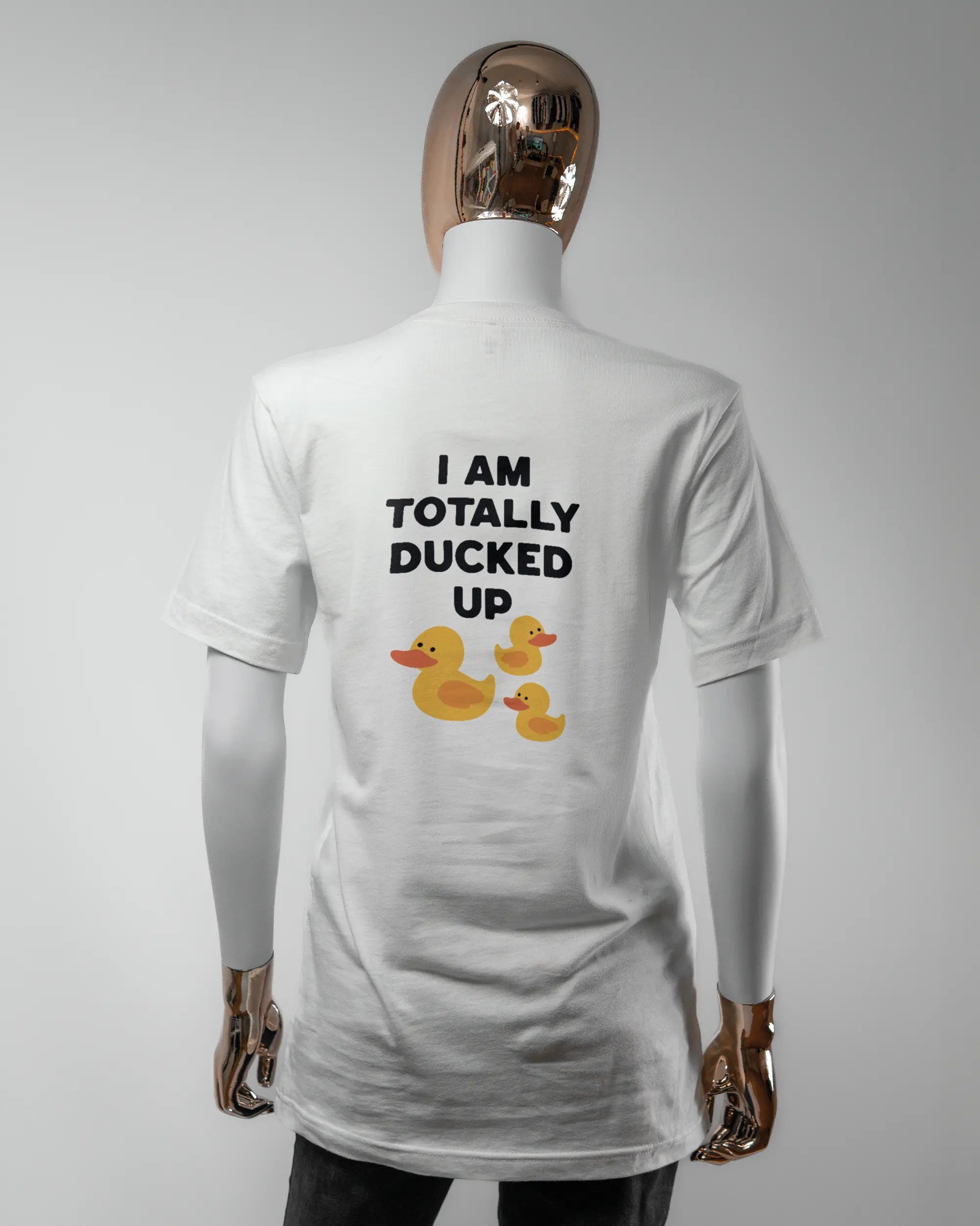 Rückseite des Basic Unisex T-Shirt Light von Maondo mit dem Design Ducked Up in der Farbe White und in der Größe S getragen von einer femininen Puppe