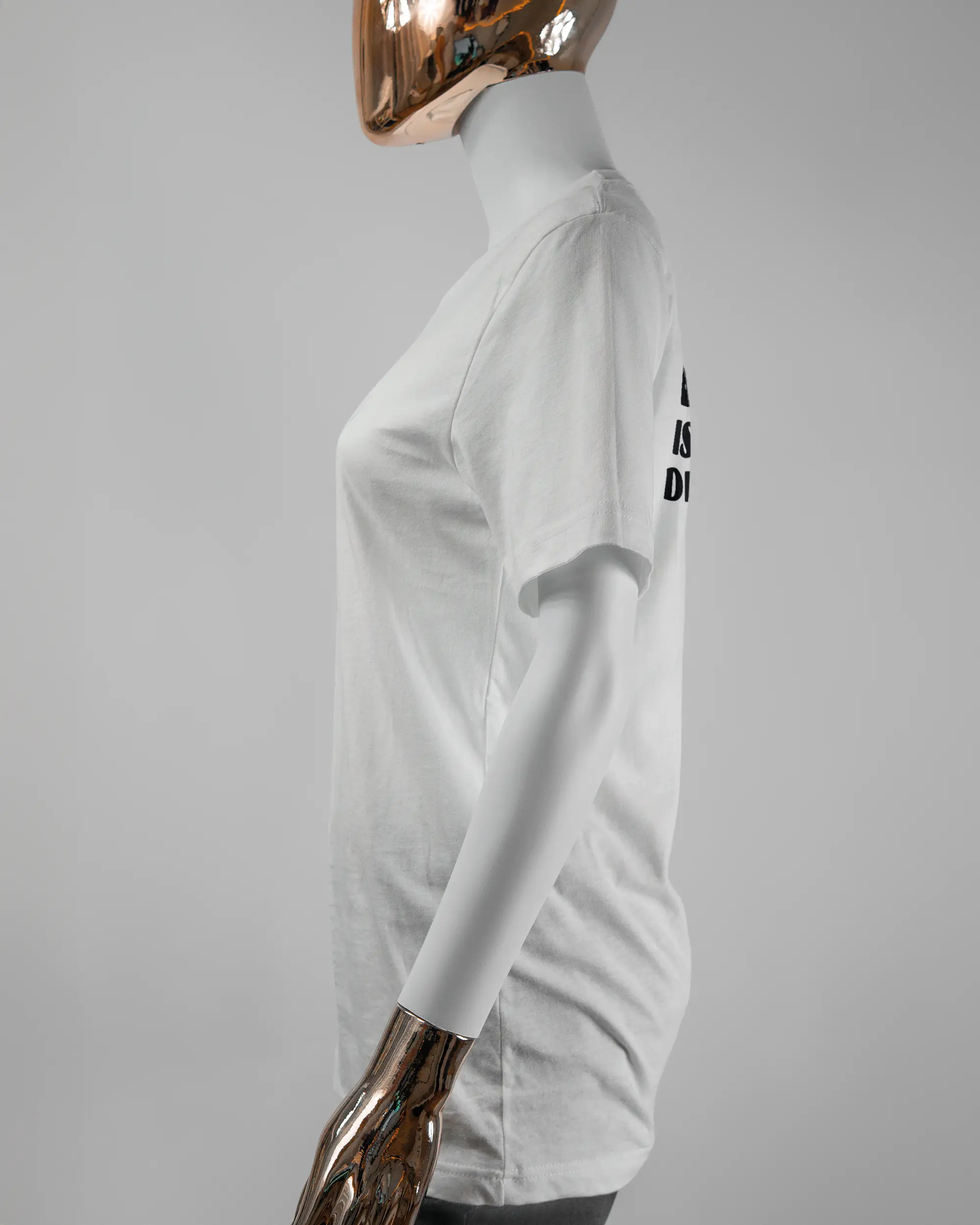 Seitenansicht des Basic Unisex T-Shirt Light von Maondo mit dem Design Keine Eile hinten in der Farbe White und in der Größe S getragen von einer femininen Puppe
