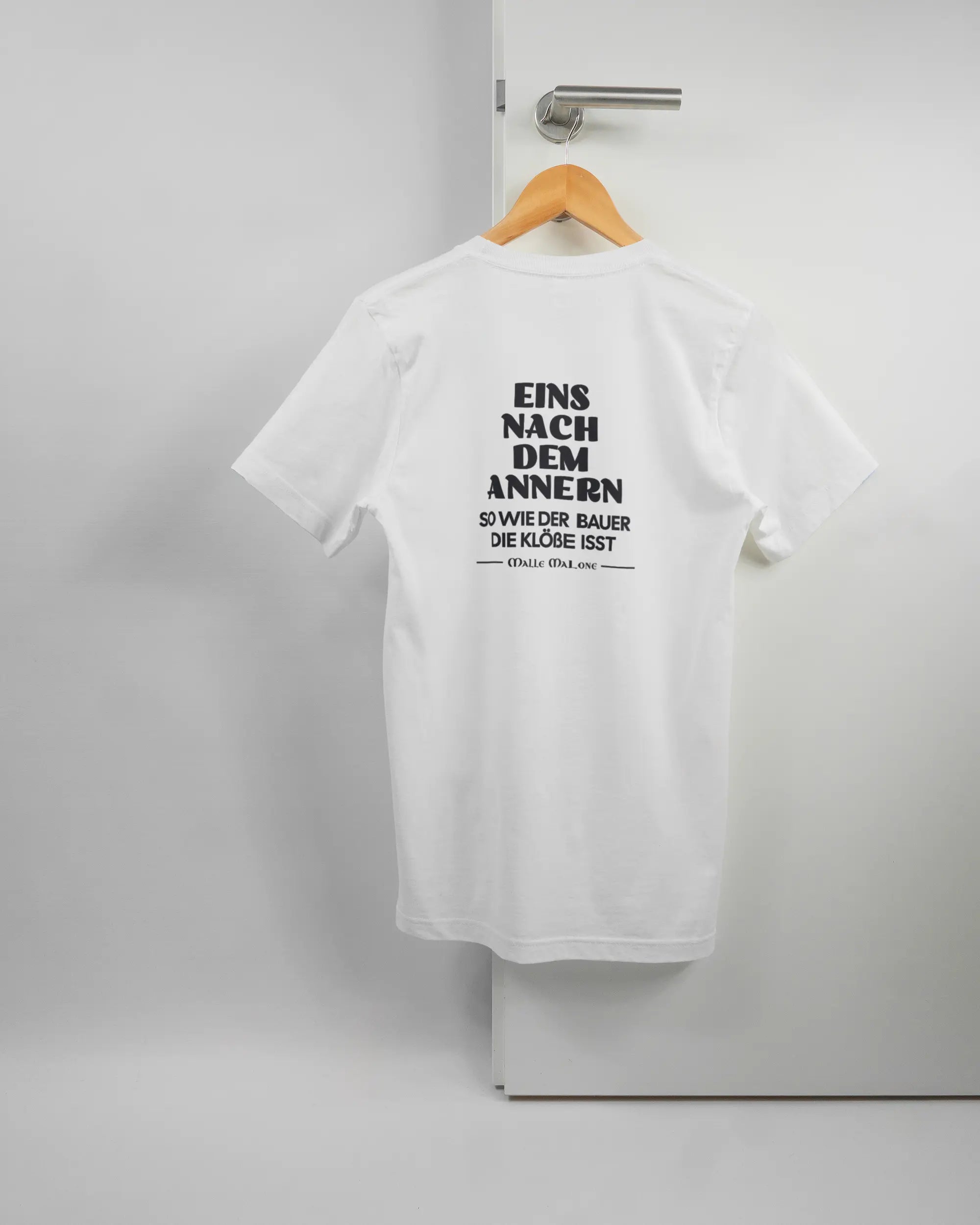 Rückseite des Basic Unisex T-Shirt Light von Maondo mit dem Design Eins nach dem Annern in der Farbe White und in der Größe S auf einem Bügel an der Türklinke aufgehängt