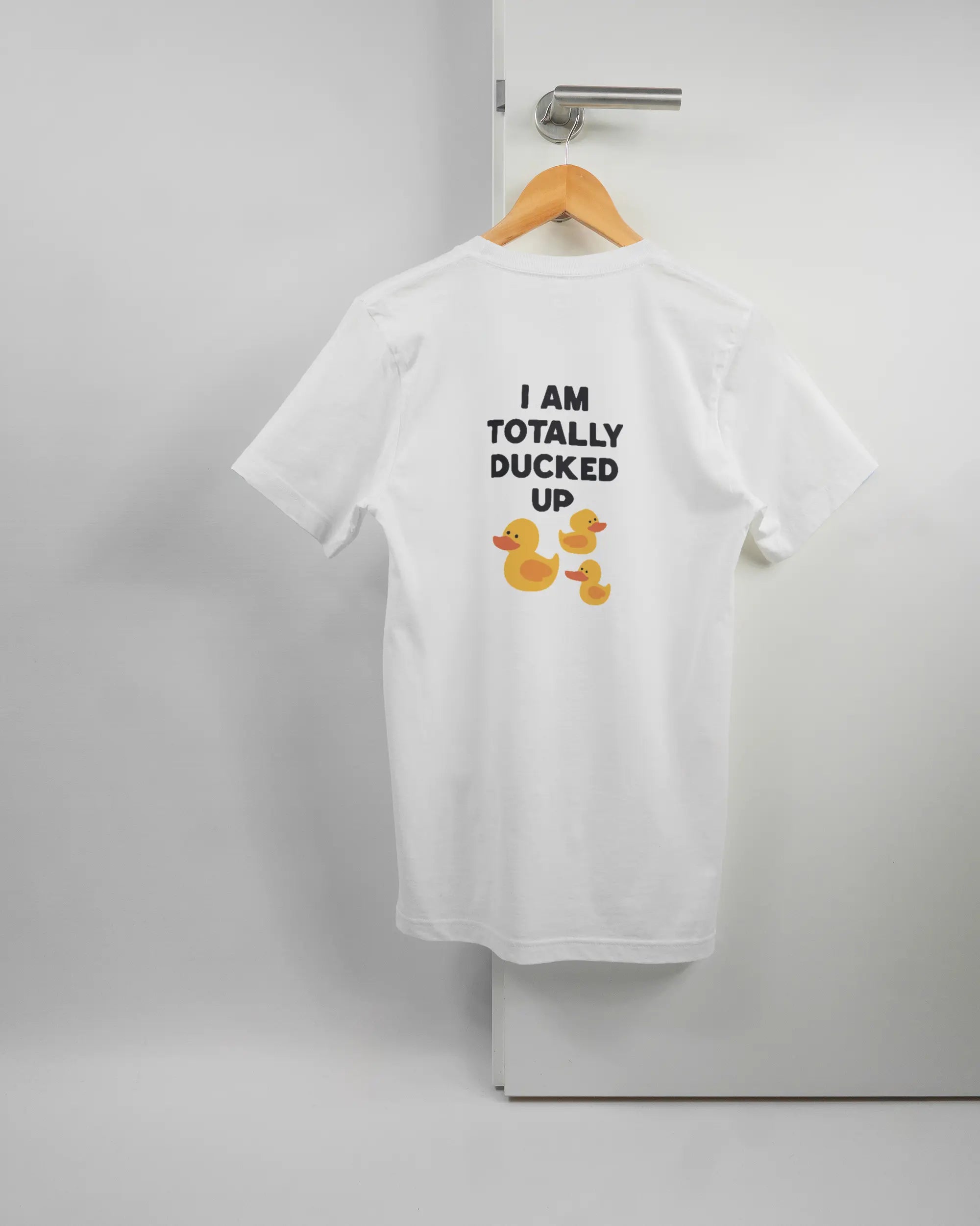 Rückseite des Basic Unisex T-Shirt Light von Maondo mit dem Design Ducked Up in der Farbe White und in der Größe S auf einem Bügel an der Türklinke aufgehängt