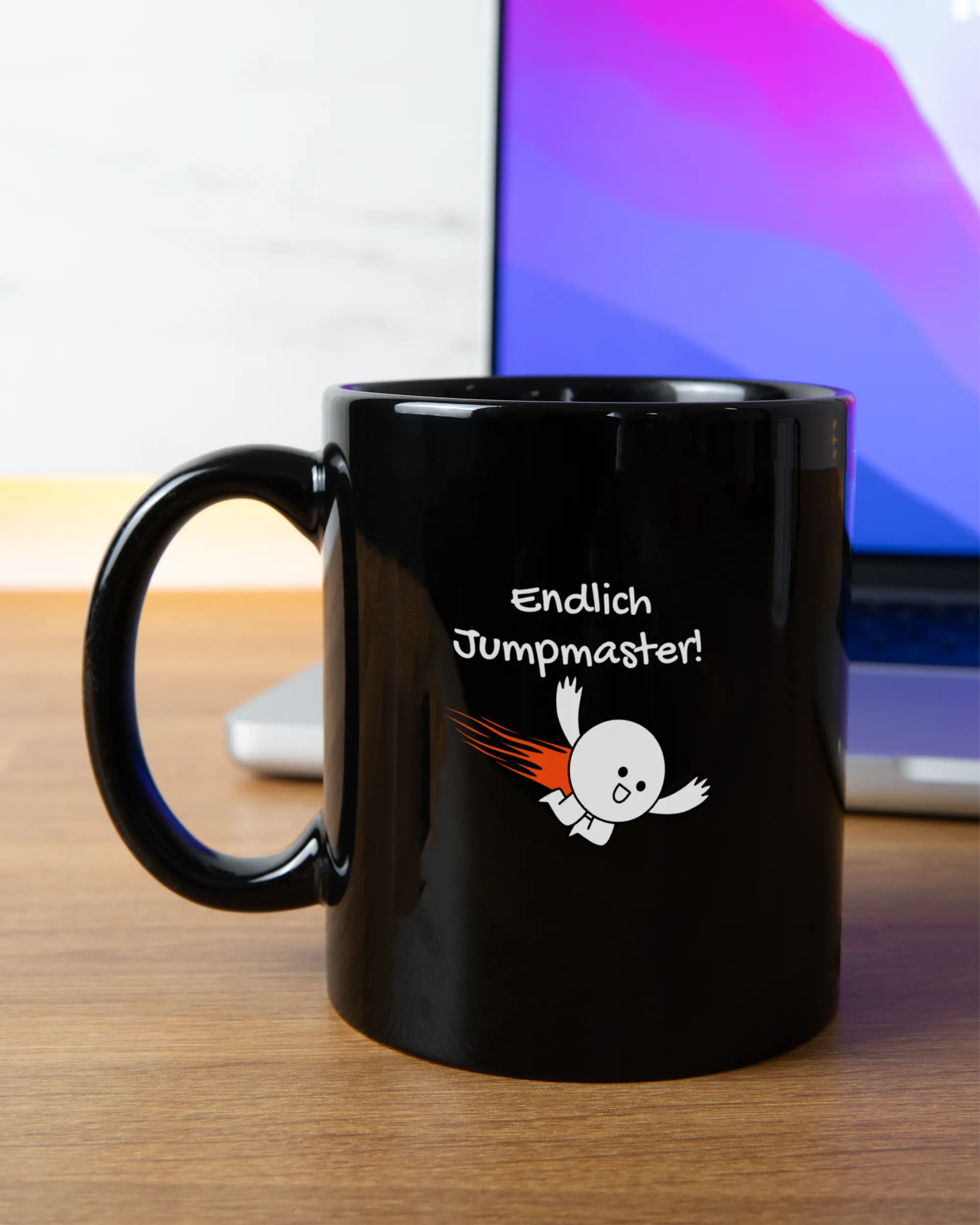 Homeoffice Aufnahme der beidseitig bedruckten Keramik Tasse von Maondo mit dem Design Endlich Jumpmaster in der Farbe Schwarz