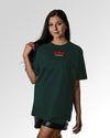 Weiblicher Modelshot der primären Druckseite des Organic Unisex T-Shirts von Maondo im Oversized Fit mit dem Design Authentic Shit in der Farbe Glazed Green