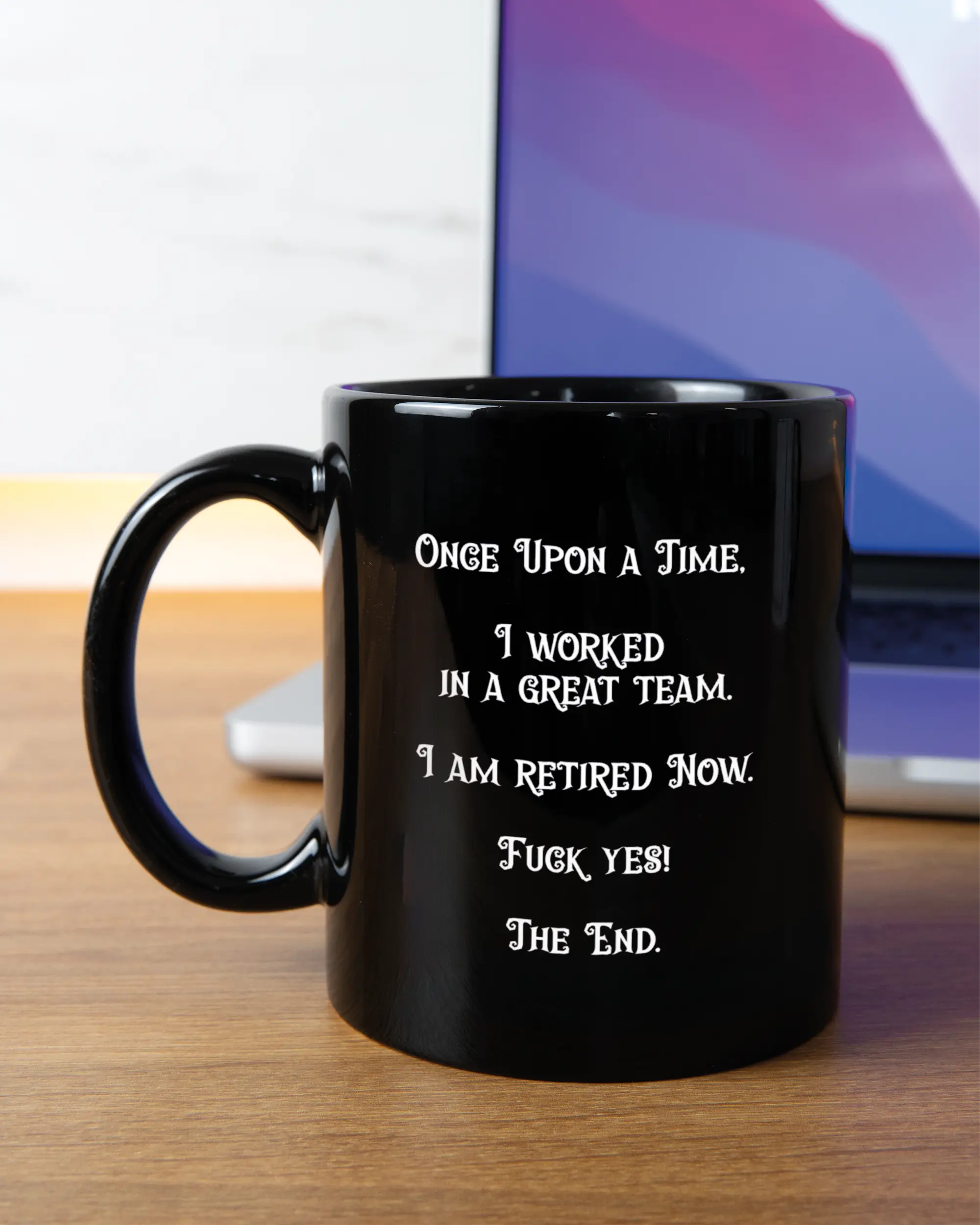 Homeoffice Aufnahme der linken Seite der beidseitig bedruckten Keramiktasse von Maondo mit dem Design Finally Retired in der Farbe Black