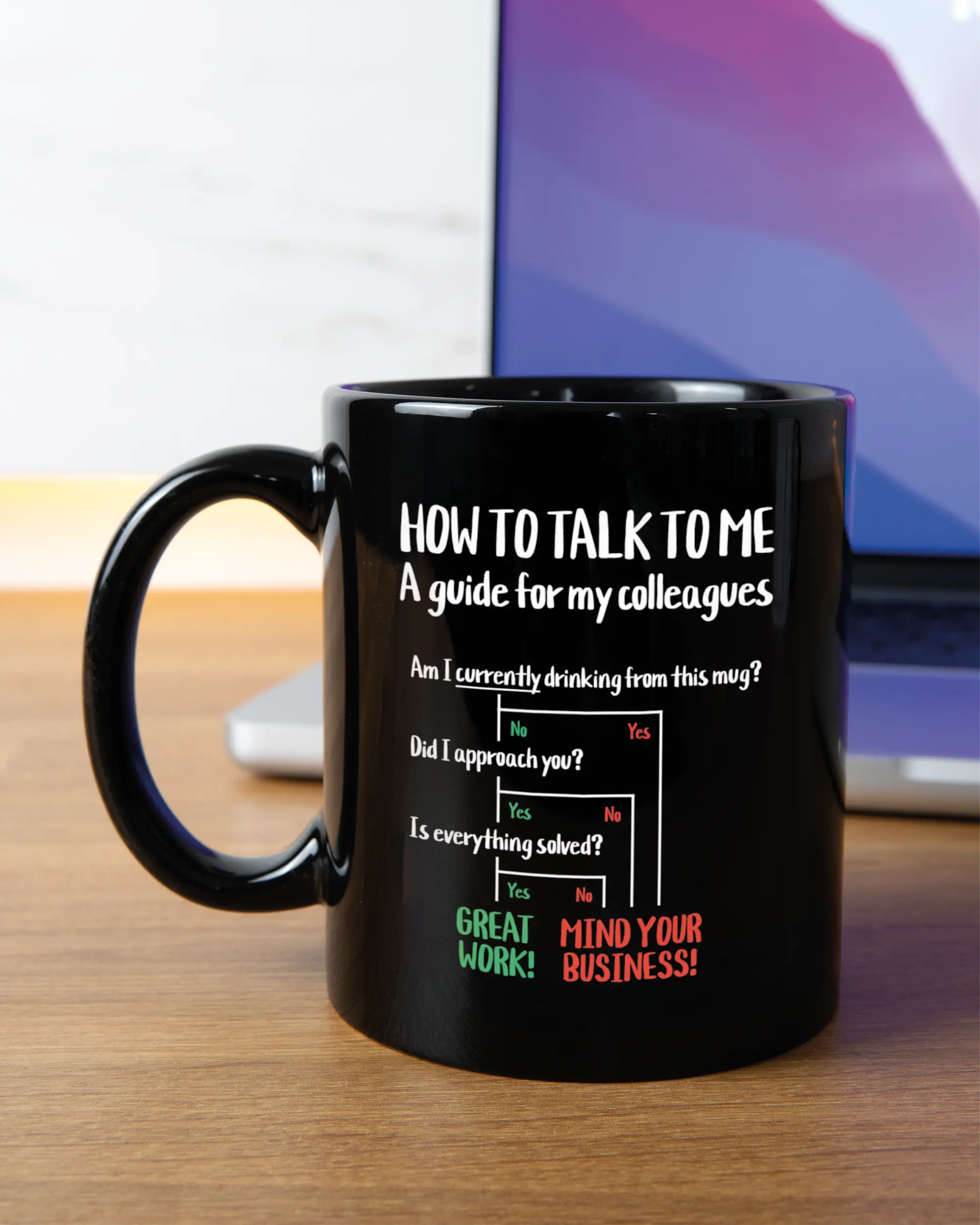 Homeoffice Aufnahme der linken Seite der beidseitig bedruckten Keramiktasse von Maondo mit dem Design Colleagues Guide in der Farbe Black