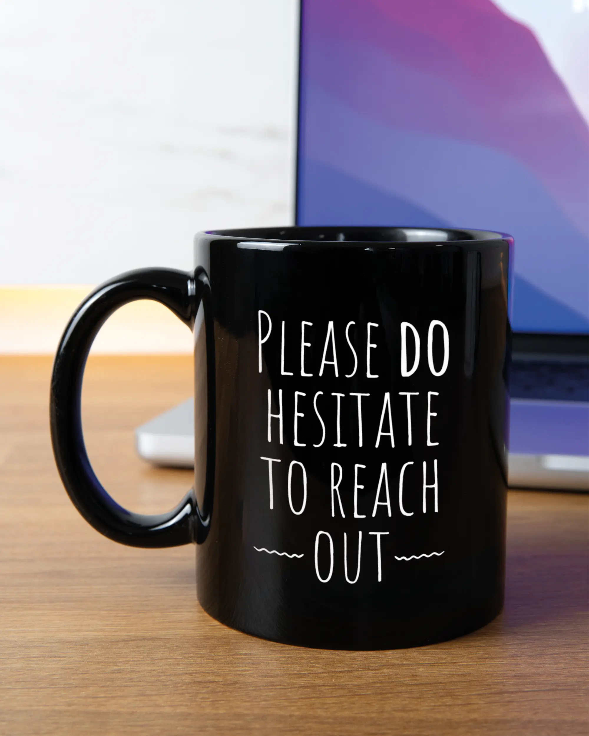 Homeoffice Aufnahme der linken Seite der beidseitig bedruckten Keramiktasse von Maondo mit dem Design Please Hesitate in der Farbe Black