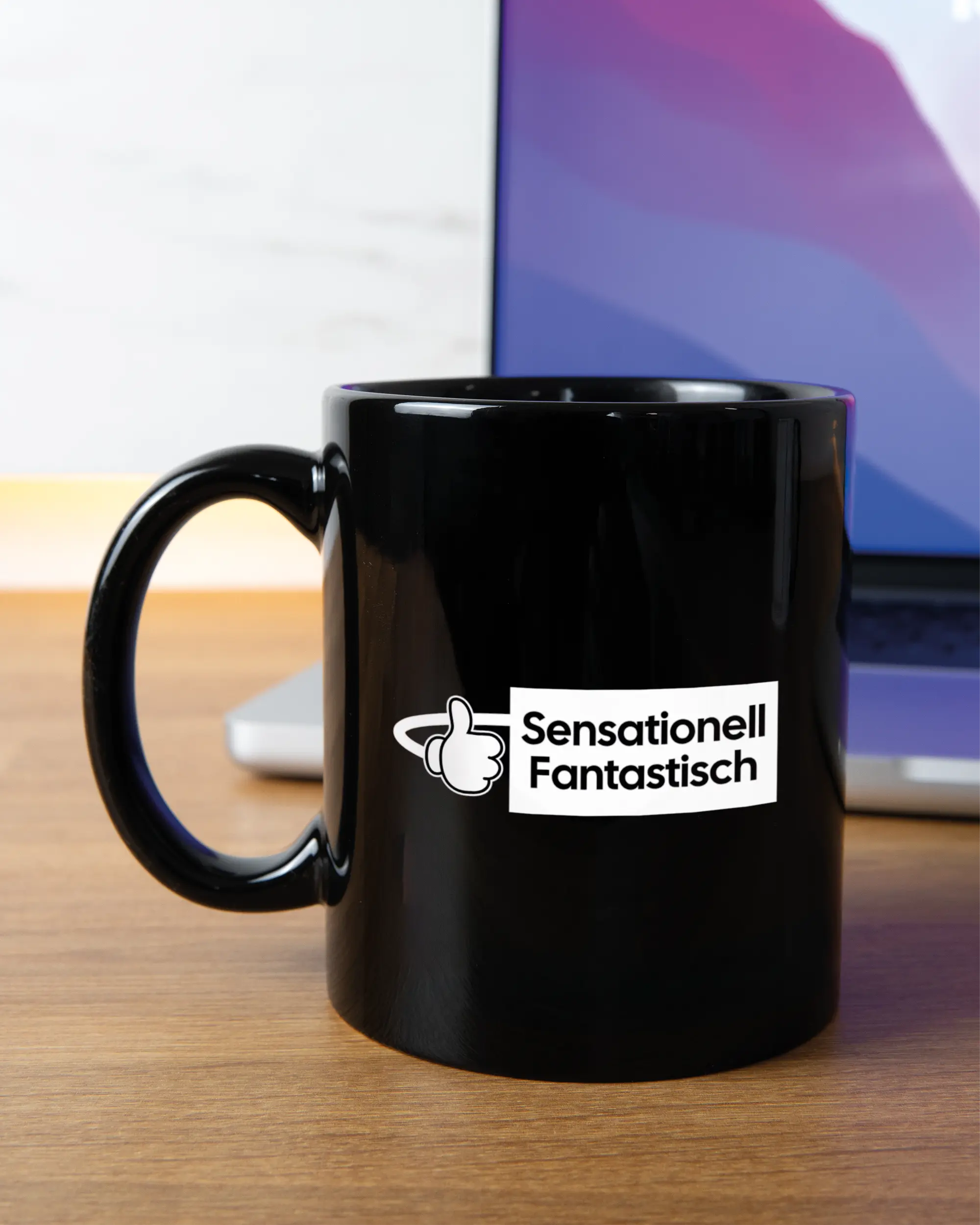 Homeoffice Aufnahme der linken Seite der beidseitig bedruckten Keramiktasse von Maondo mit dem Design Fantastisch in der Farbe Black