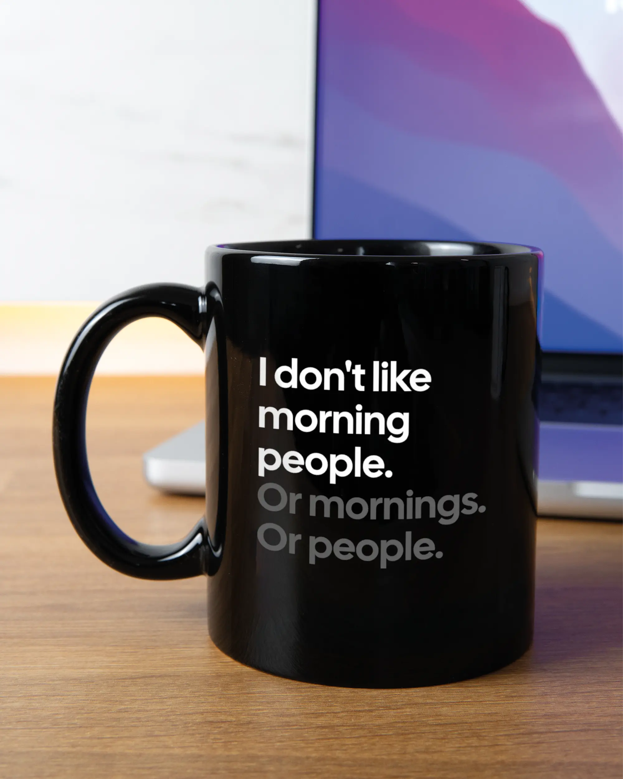 Homeoffice Aufnahme der linken Seite der beidseitig bedruckten Keramiktasse von Maondo mit dem Design Morning Person in der Farbe Black