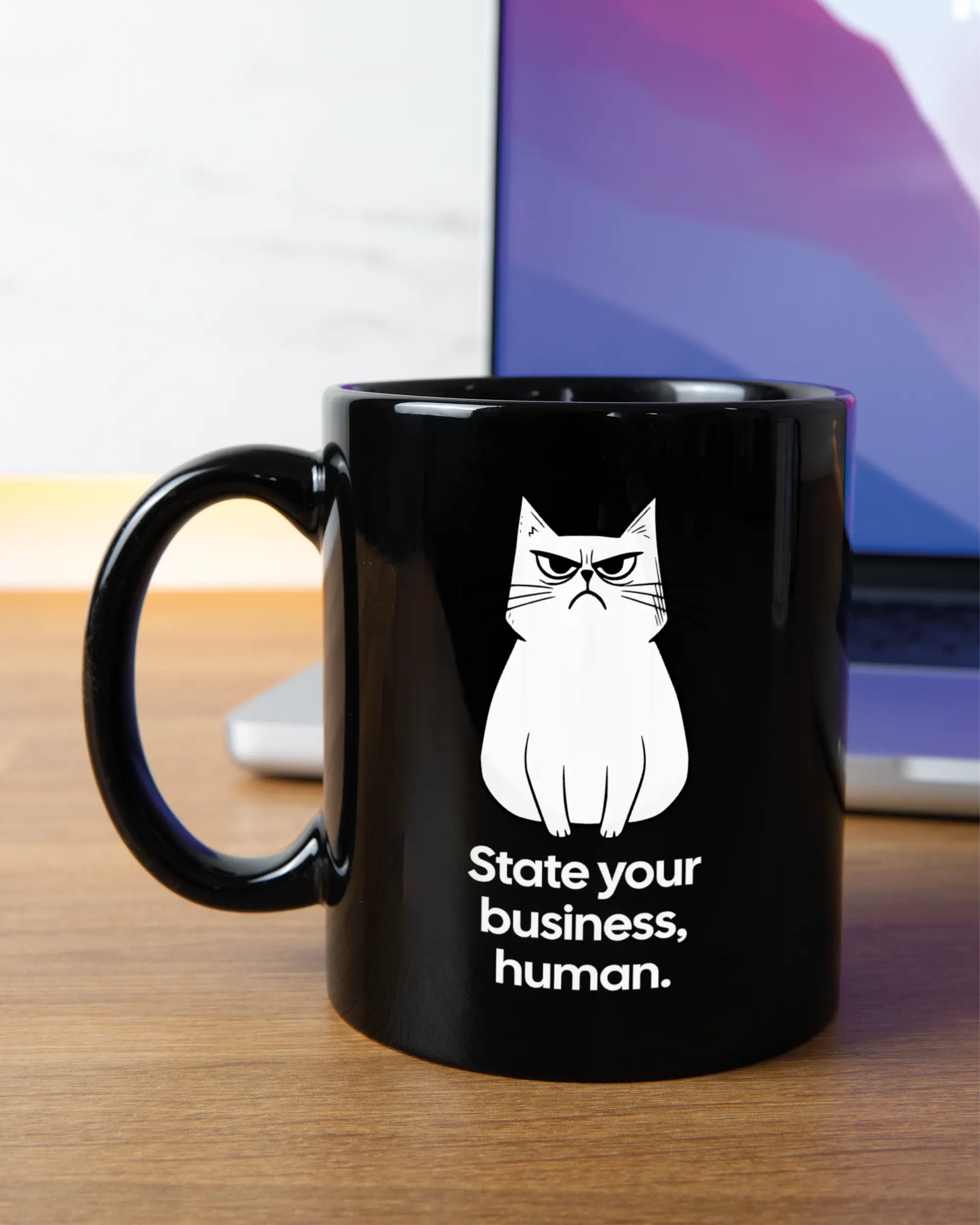 Homeoffice Aufnahme der linken Seite der beidseitig bedruckten Keramiktasse von Maondo mit dem Design Grumpy Purr in der Farbe Black