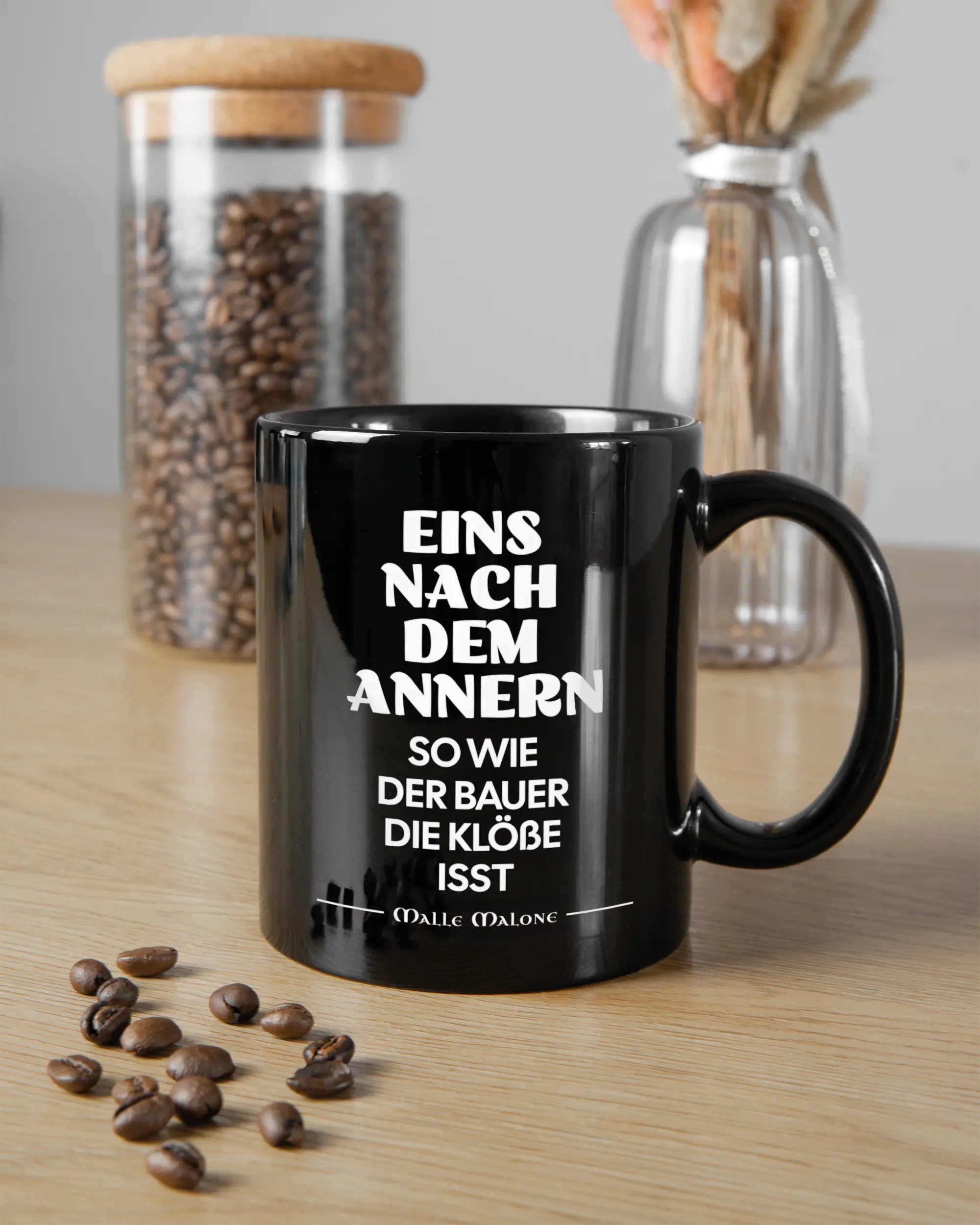 Küchentischansicht der rechten Seite der beidseitig bedruckten Keramiktasse von Maondo mit dem Design Eins nach dem Annern in der Farbe Black